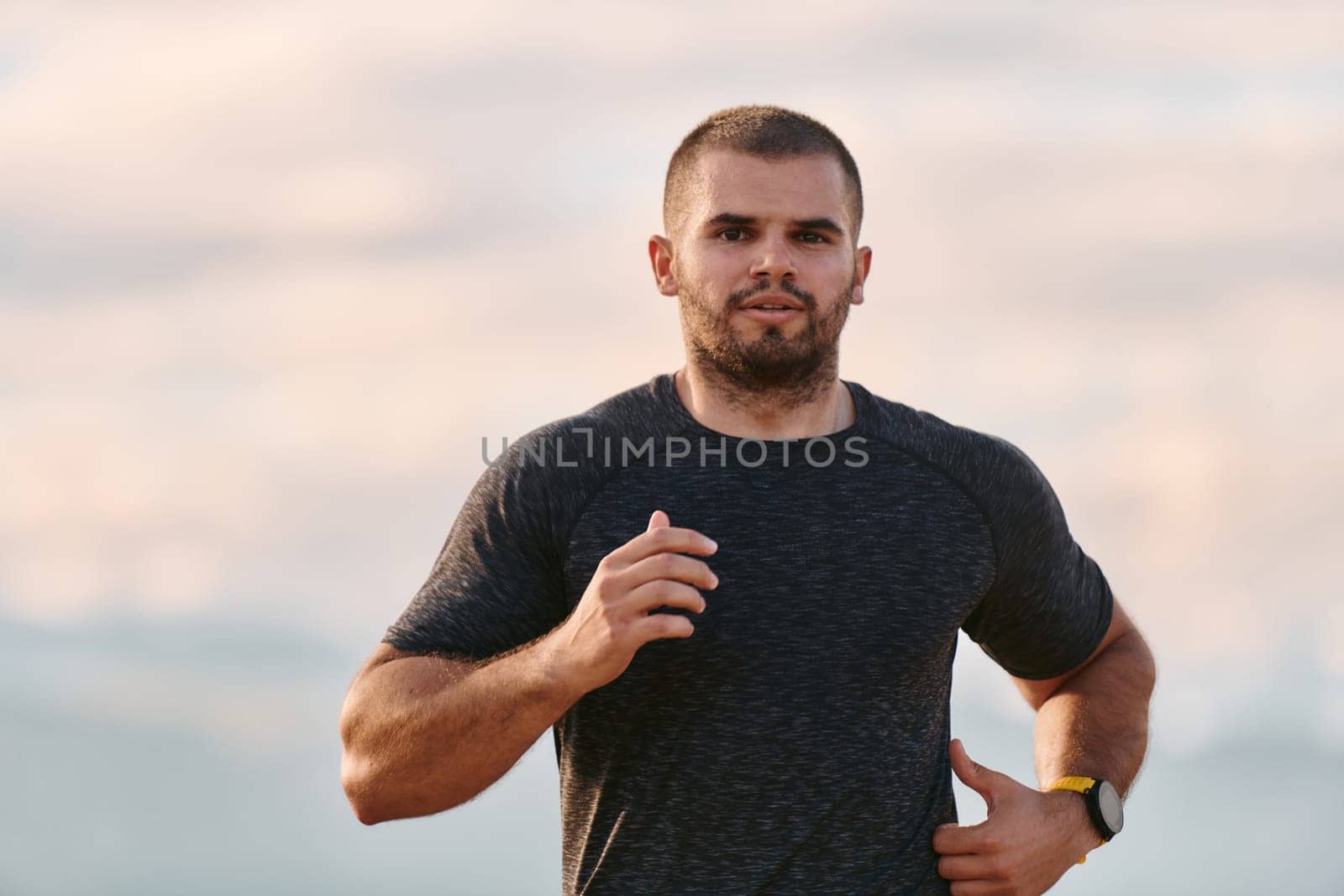 An athletic man jogs under the sun, conditioning his body for life's extreme challenges, exuding determination and strength in his preparation for the journey ahead