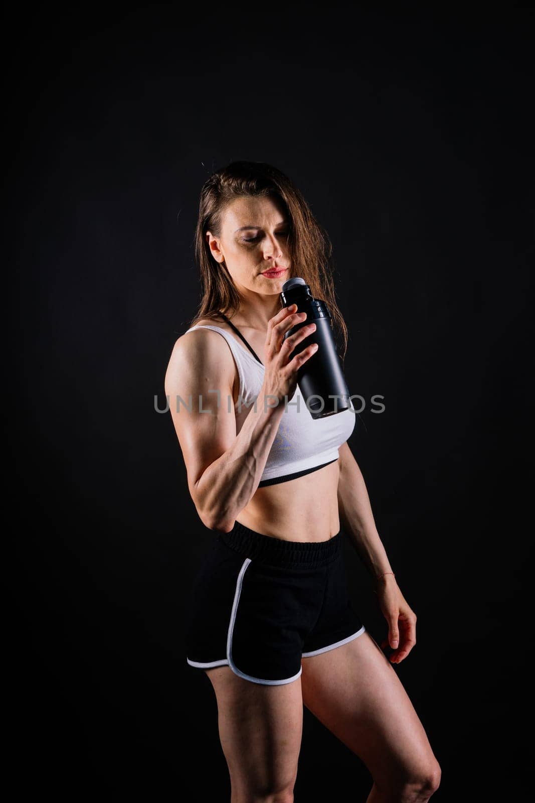 Sporty female drinking water after workout. Photo of a fitness woman. Healthy lifestyle