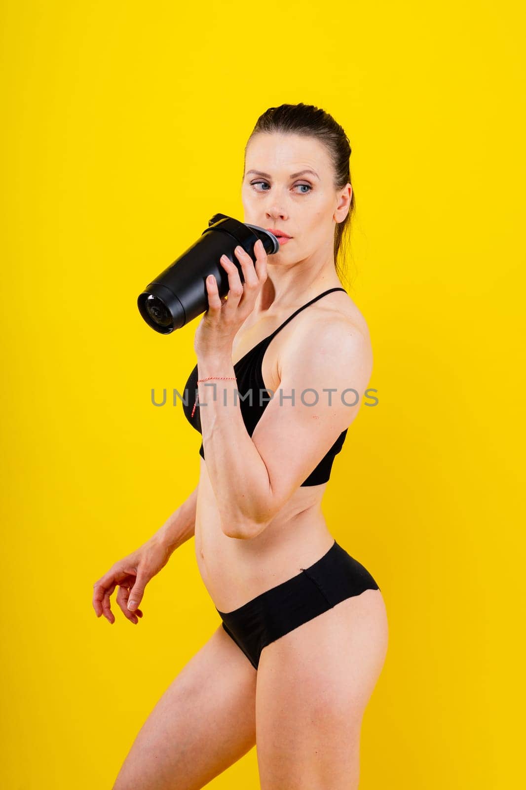 Sporty female drinking water after workout. Photo of fitness woman. Healthy lifestyle by Zelenin