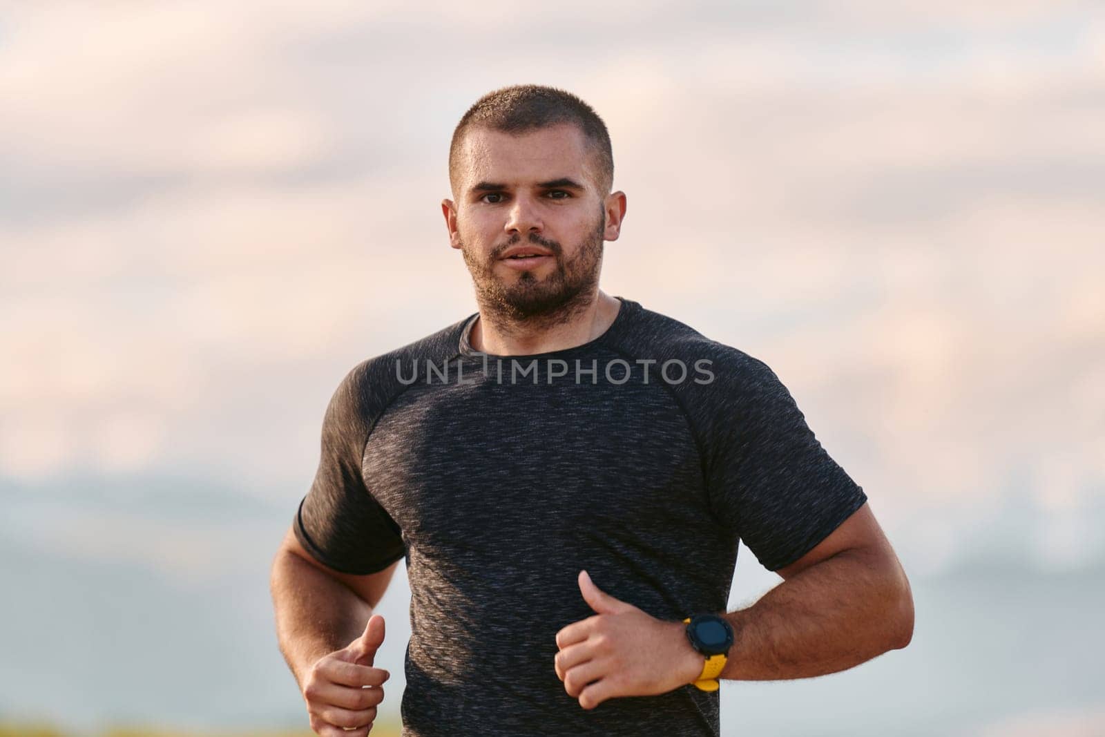 An athletic man jogs under the sun, conditioning his body for life's extreme challenges, exuding determination and strength in his preparation for the journey ahead