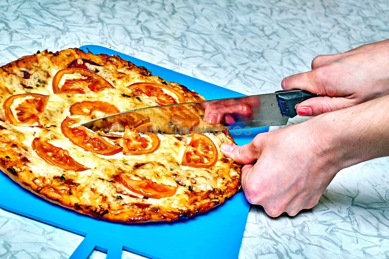 Cutting freshly prepared pizza with a knife.Ready to eat baked pizza by jovani68