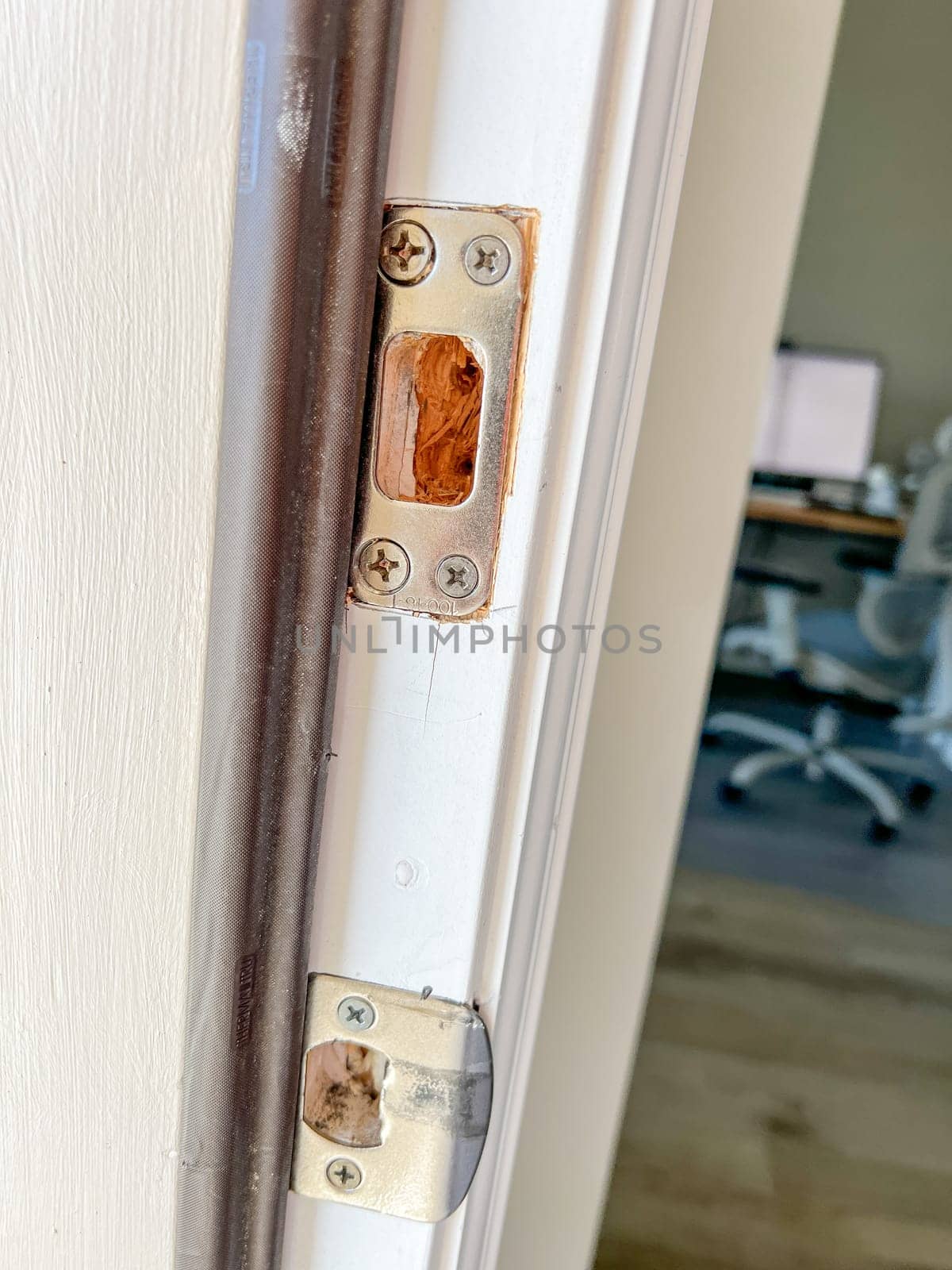 Denver, Colorado, USA-November 25, 2023-Detailed view of a door frame with lock hardware removed, showing the doors edge and lock cutouts. The photo captures the preparation phase for installing a new door lock or handle.