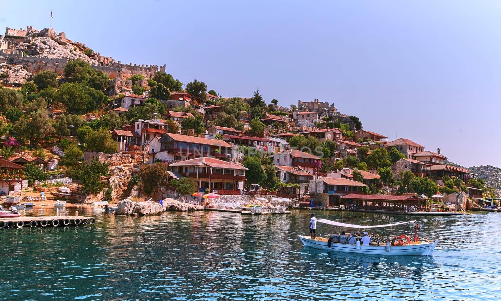 Experience the charm of traditional Turkish architecture as you cruise along serene waters, admiring quaint houses against a picturesque landscape, capturing the essence of this historic heritage.