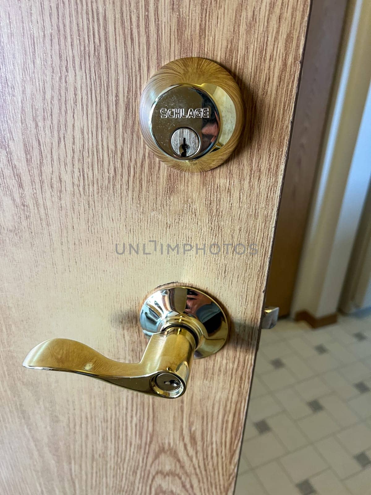 Polished Brass Door Handle and Deadbolt on Wooden Door by arinahabich