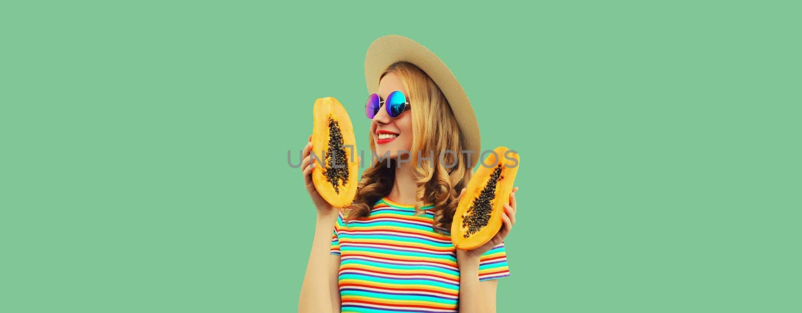 Summer portrait of happy cheerful young woman with fresh papaya fruits on green background by Rohappy