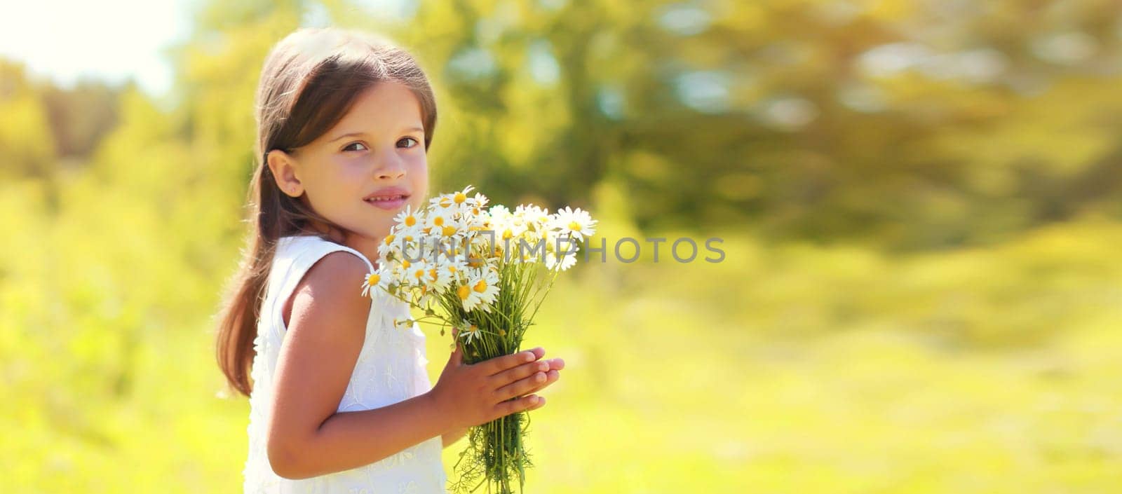 Cute girl child with wildflowers in sunny summer park by Rohappy