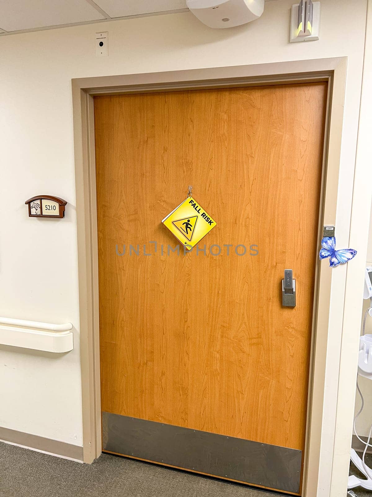 Denver, Colorado, USA-September 13, 2023-A hospital room door with a Fall Risk sign and a butterfly symbol, indicating the occupant is in hospice care and near the end of life. The setting reflects the sensitive and caring environment of a healthcare facility.