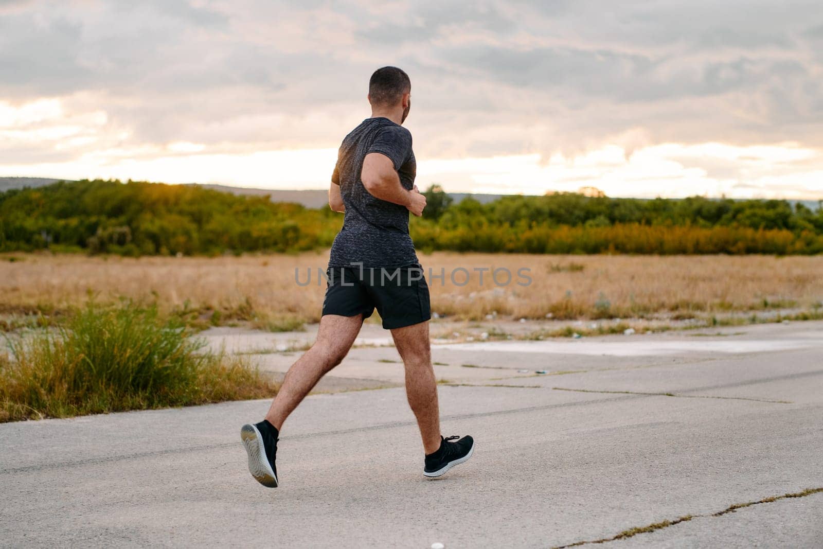 Athletic Man Jogging in the Sun, Preparing His Body for Life's Extreme Challenges by dotshock