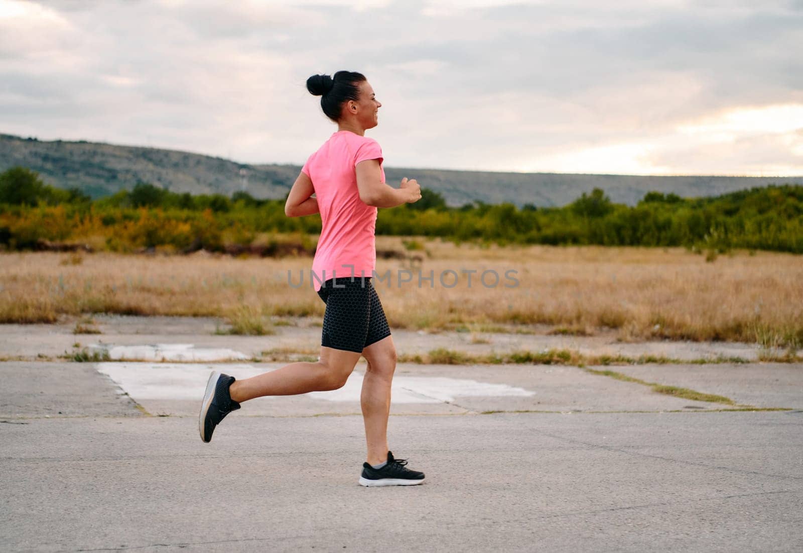 Determined Athlete Running in the Sun amidst Beautiful Nature by dotshock