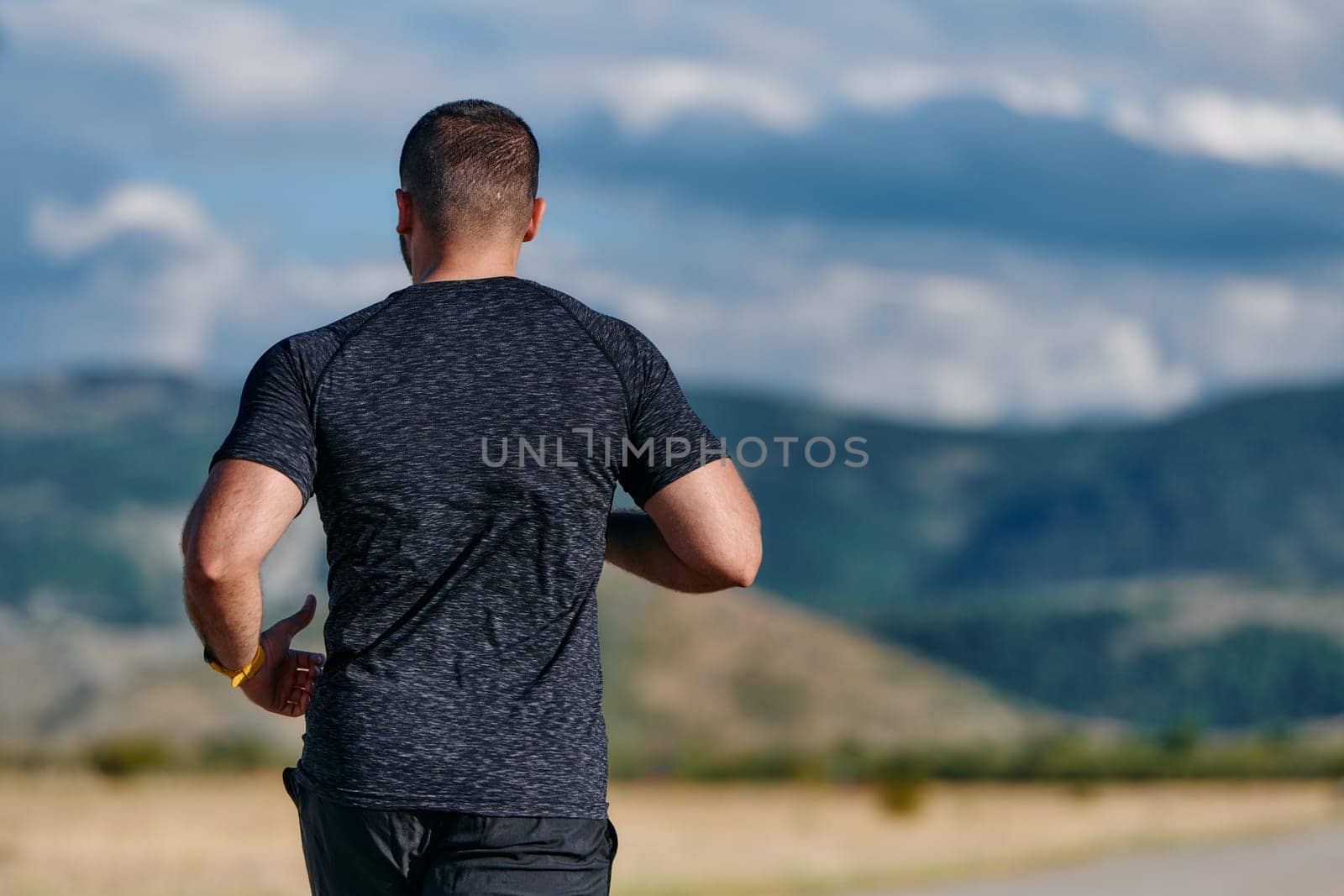 An athletic man jogs under the sun, conditioning his body for life's extreme challenges, exuding determination and strength in his preparation for the journey ahead