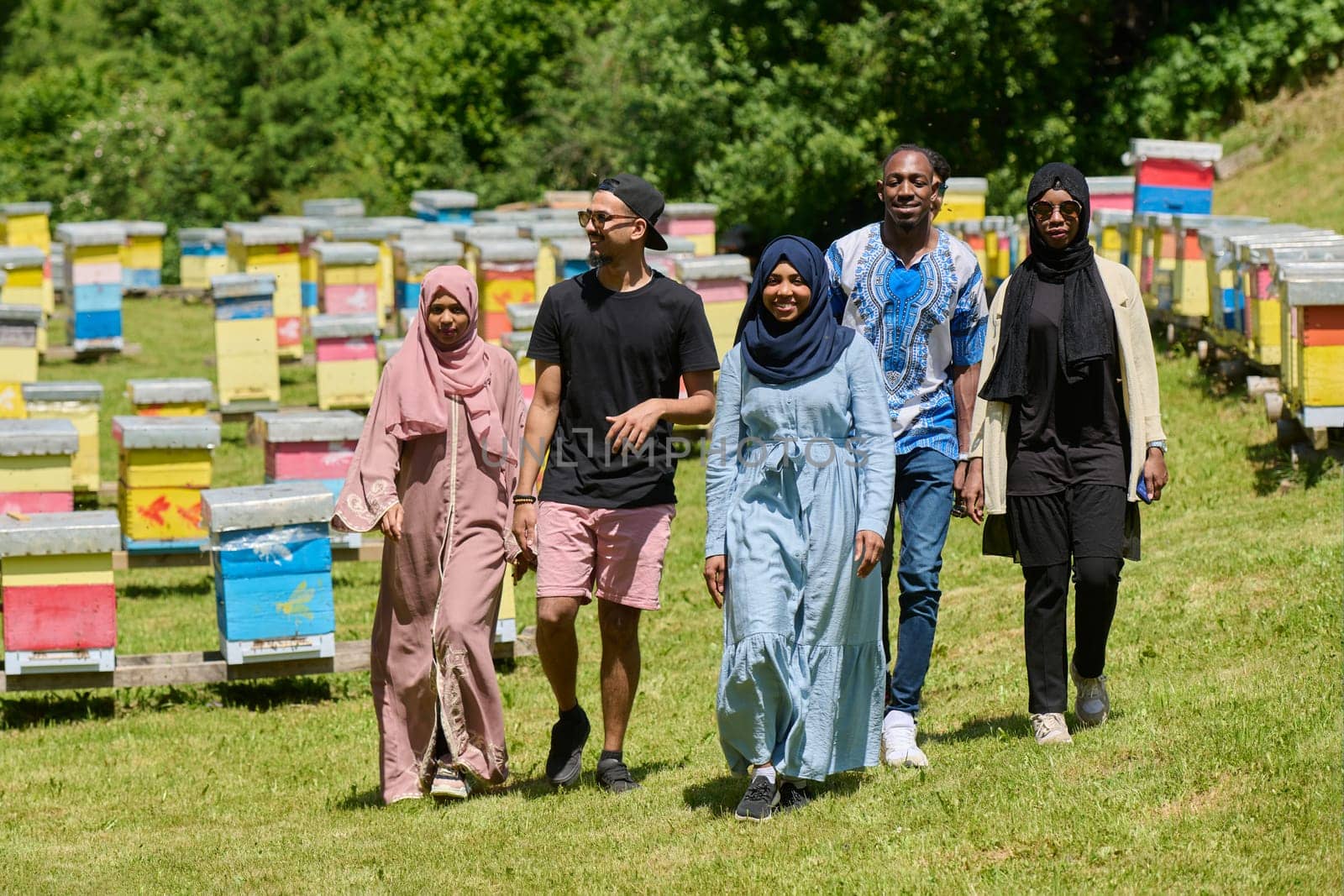 A diverse group of young friends and entrepreneurs explore small honey production businesses in the natural setting of the countryside. by dotshock