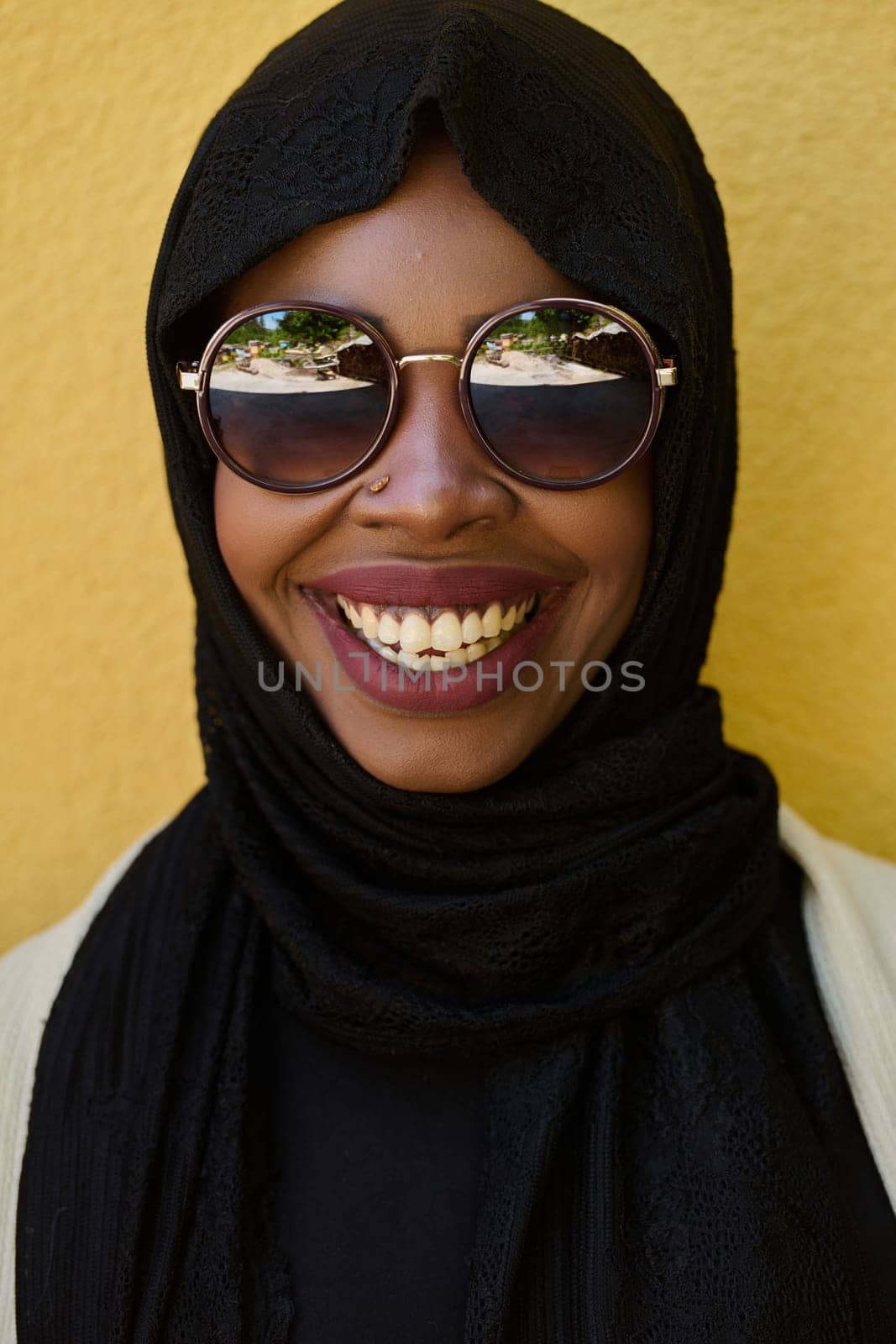 Close Up Portrait of Middle Eastern Muslim Woman Against Yellow Background by dotshock