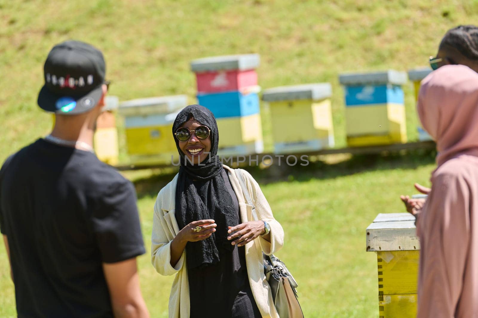 A diverse group of young friends and entrepreneurs explore small honey production businesses in the natural setting of the countryside. by dotshock