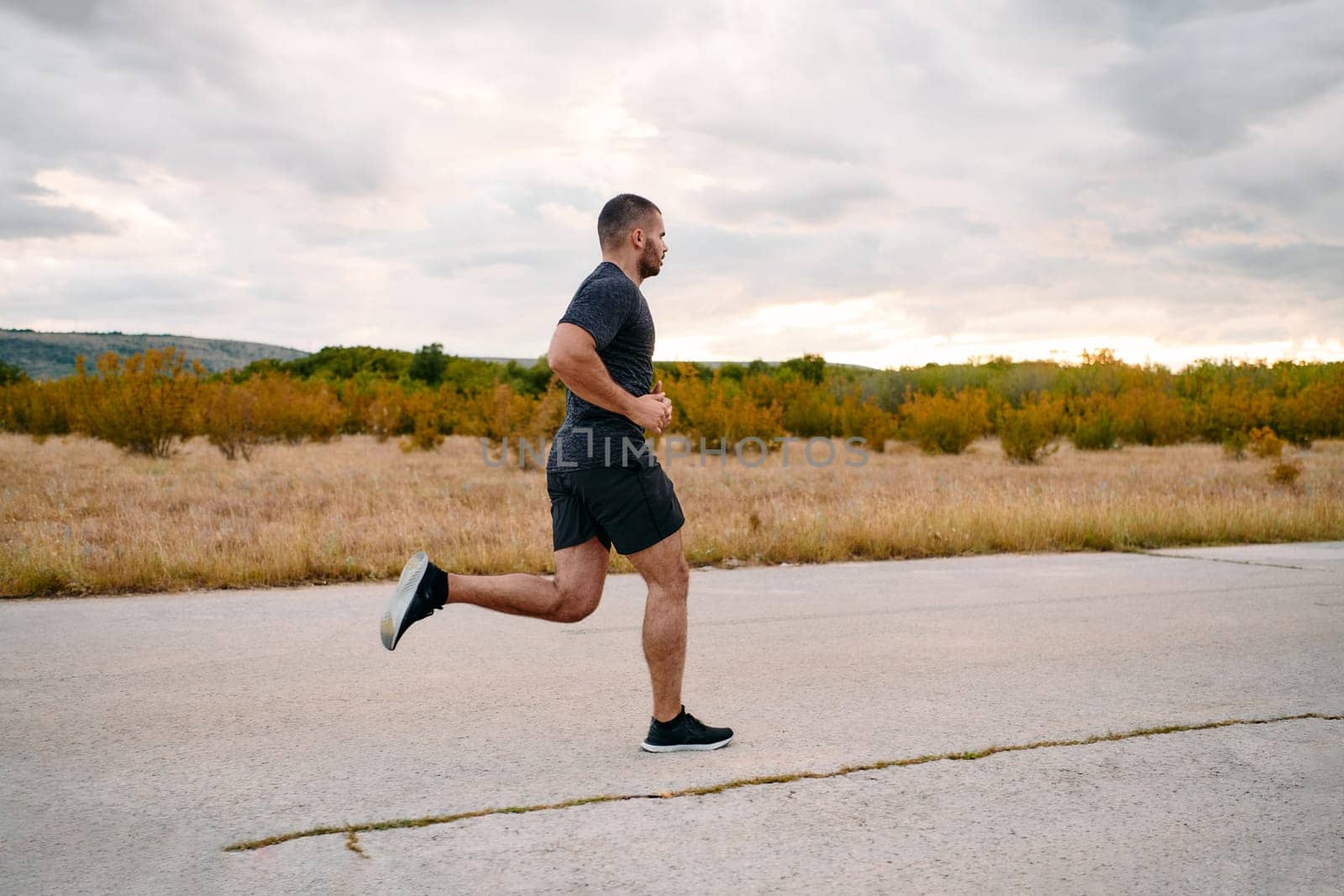 Athletic Man Jogging in the Sun, Preparing His Body for Life's Extreme Challenges by dotshock