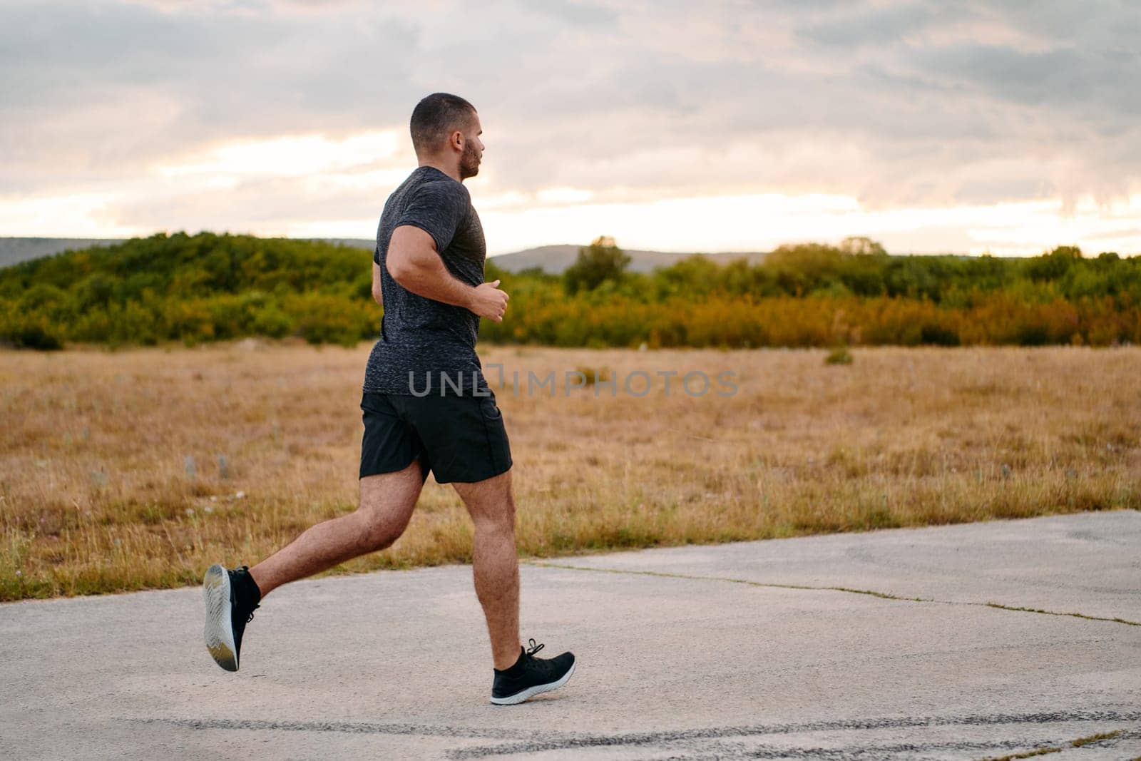 Athletic Man Jogging in the Sun, Preparing His Body for Life's Extreme Challenges by dotshock