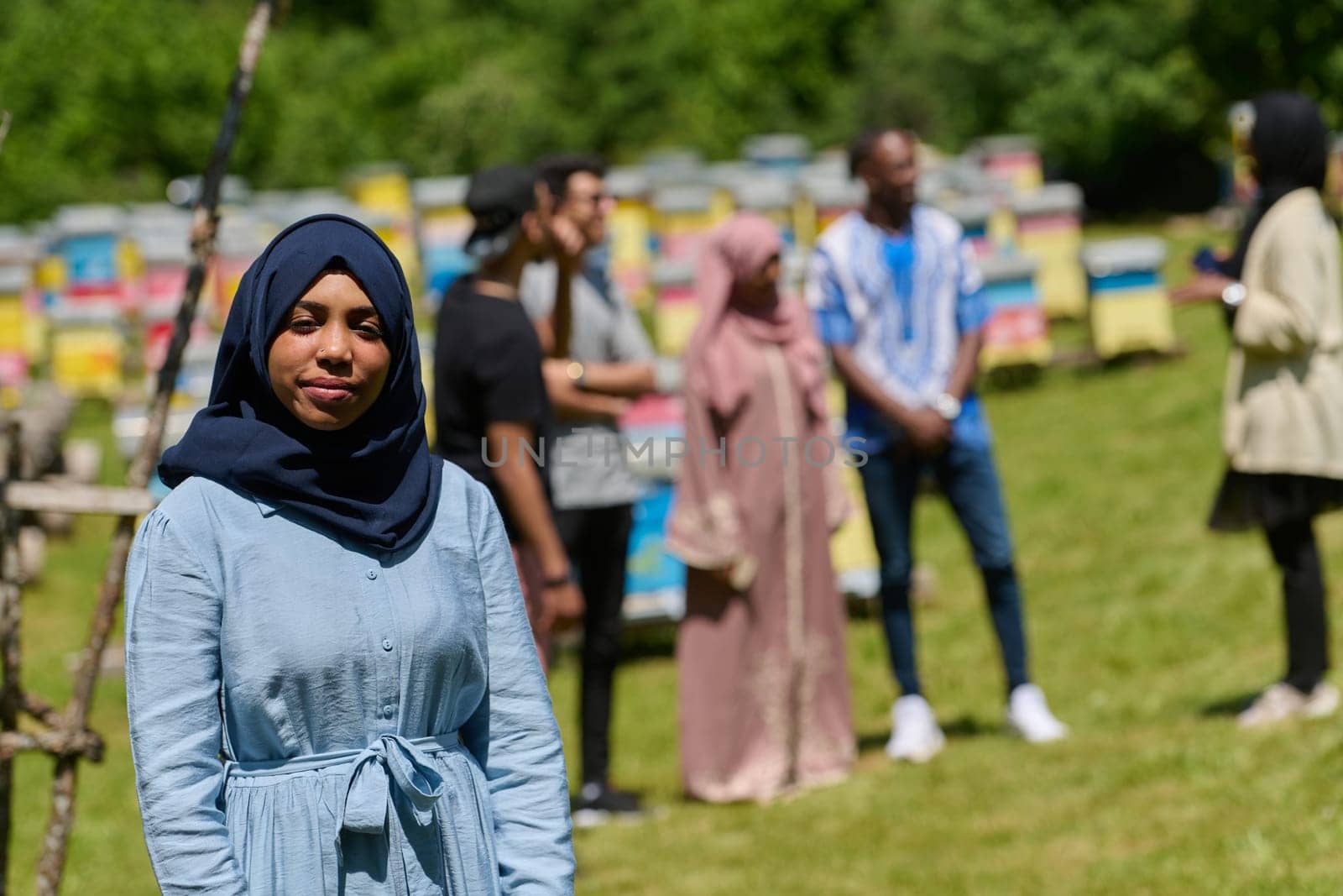 African American Muslim woman in hijab explores natural bee farms for honey production, blending tradition with sustainability in the serene countryside.