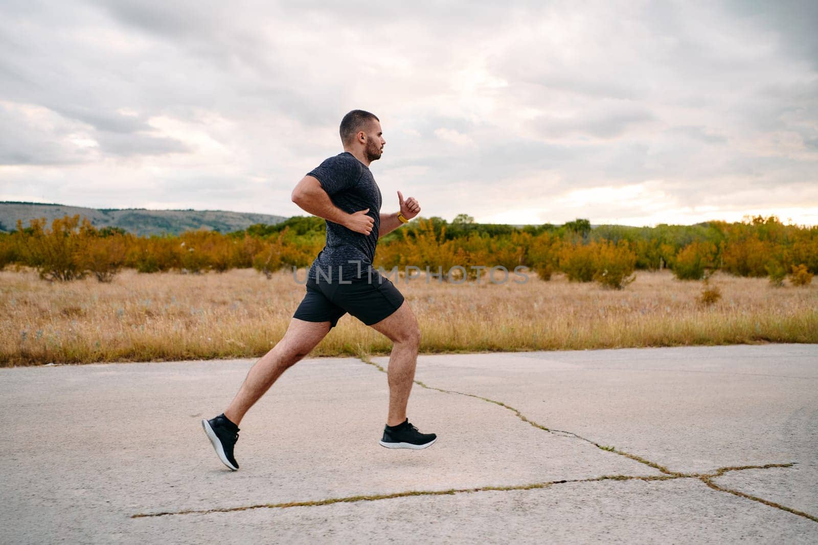 Athletic Man Jogging in the Sun, Preparing His Body for Life's Extreme Challenges by dotshock