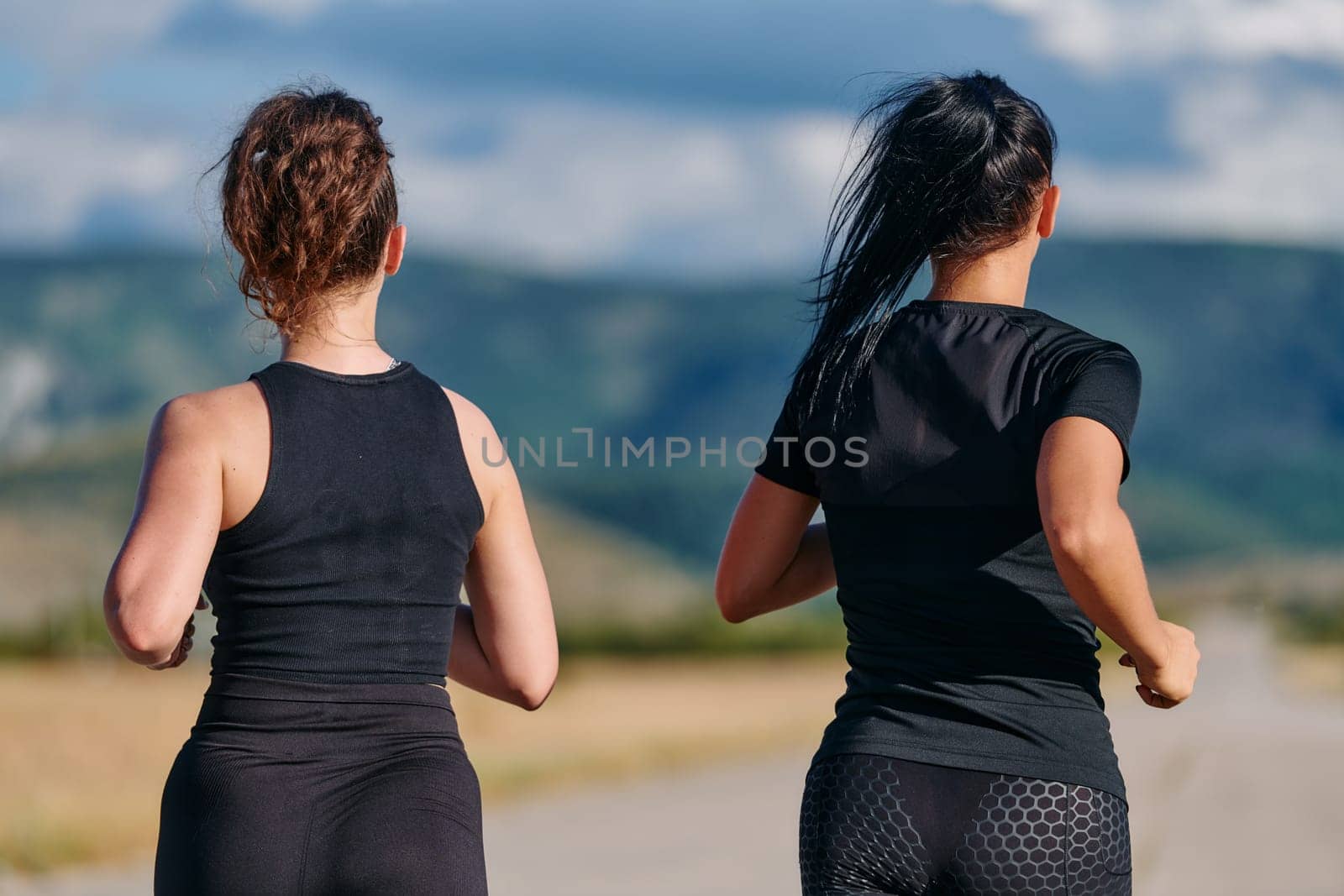 Two friends jog side by side on a sunny day, strengthening their bodies for life's extreme challenges, embodying the power of friendship and determination