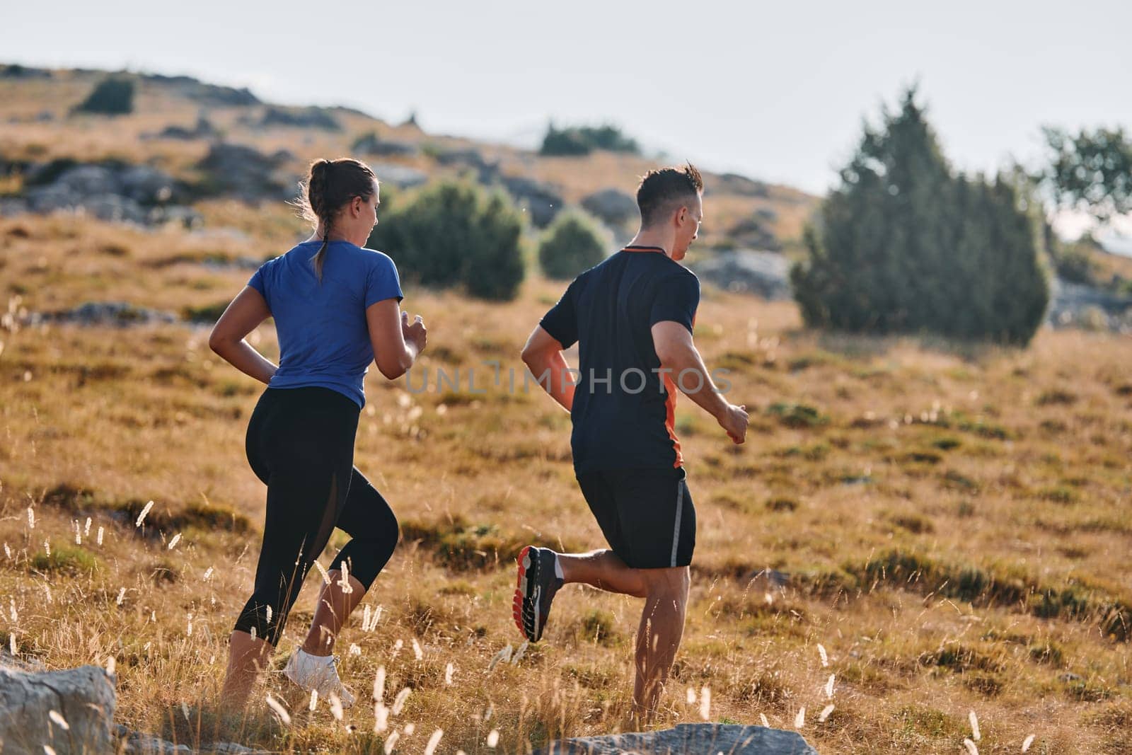 Couple conquer challenging mountain trails during an invigorating morning run.