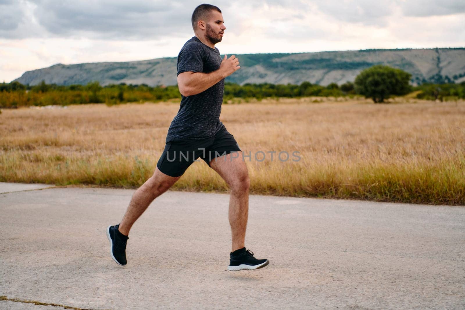 Athletic Man Jogging in the Sun, Preparing His Body for Life's Extreme Challenges by dotshock