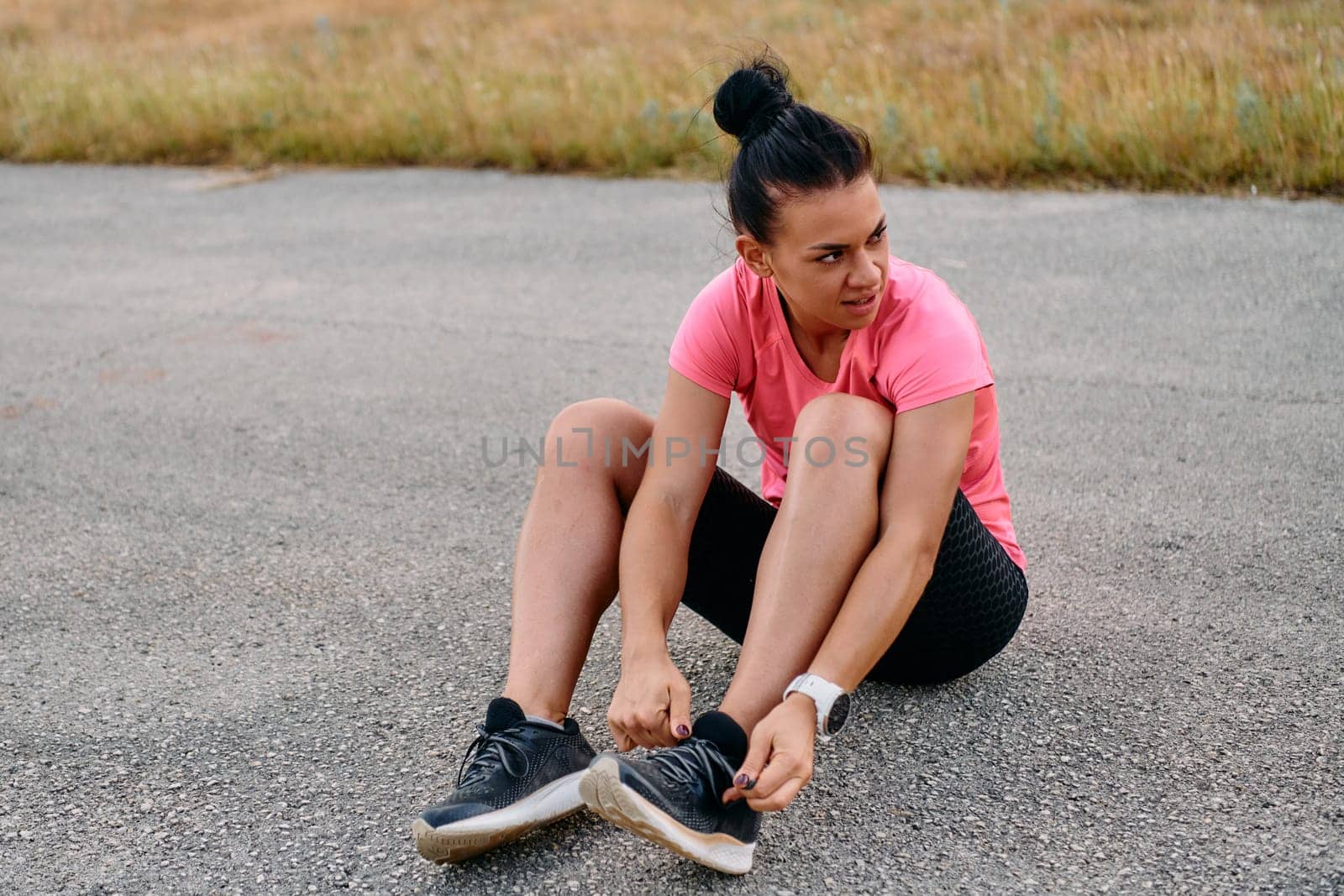 An athletic woman prepares herself for a morning run, embodying dedication and determination in her fitness routine