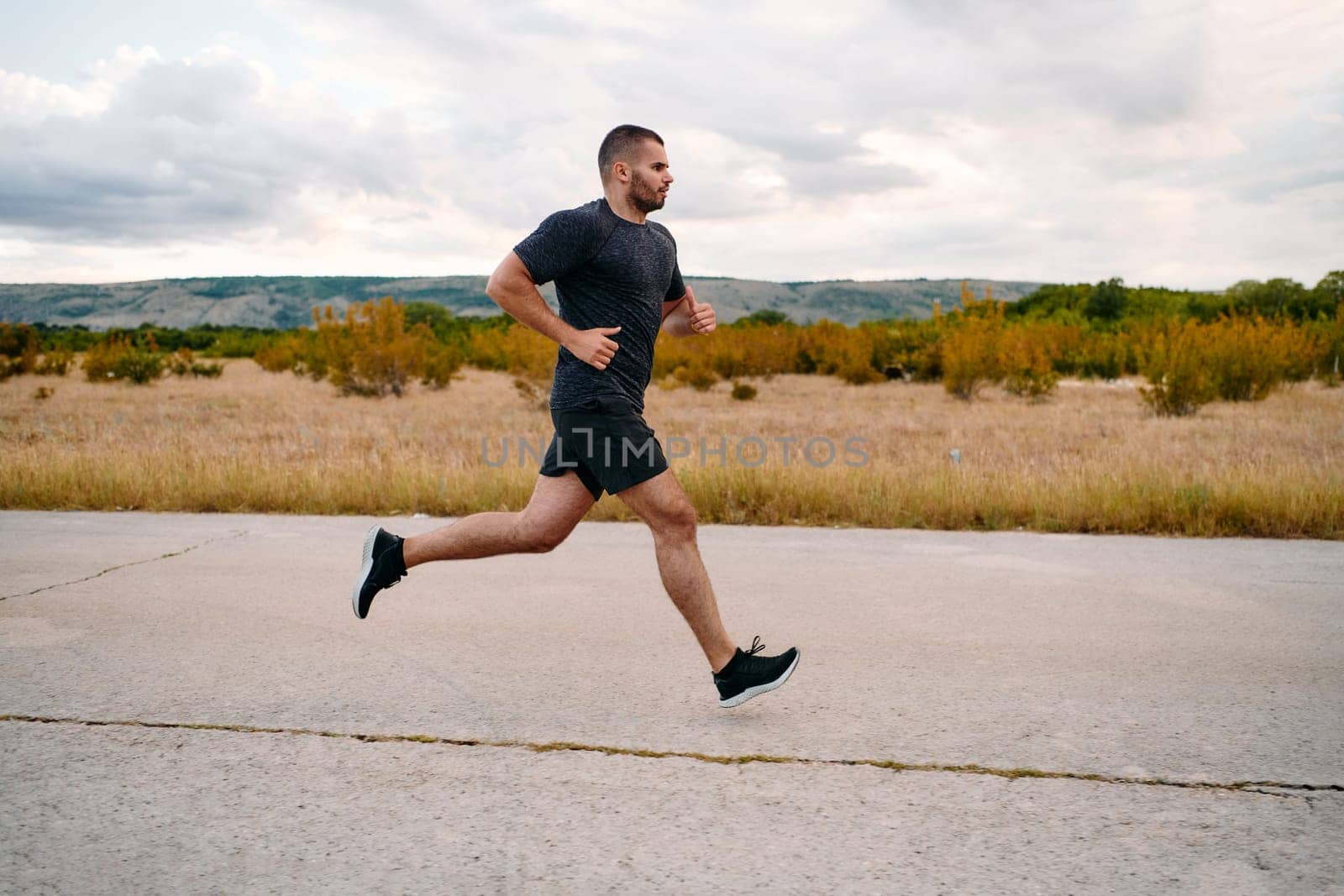 Athletic Man Jogging in the Sun, Preparing His Body for Life's Extreme Challenges by dotshock