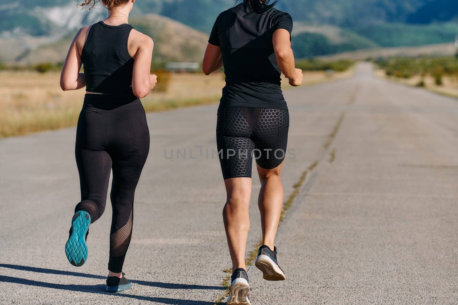 Two friends jog side by side on a sunny day, strengthening their bodies for life's extreme challenges, embodying the power of friendship and determination