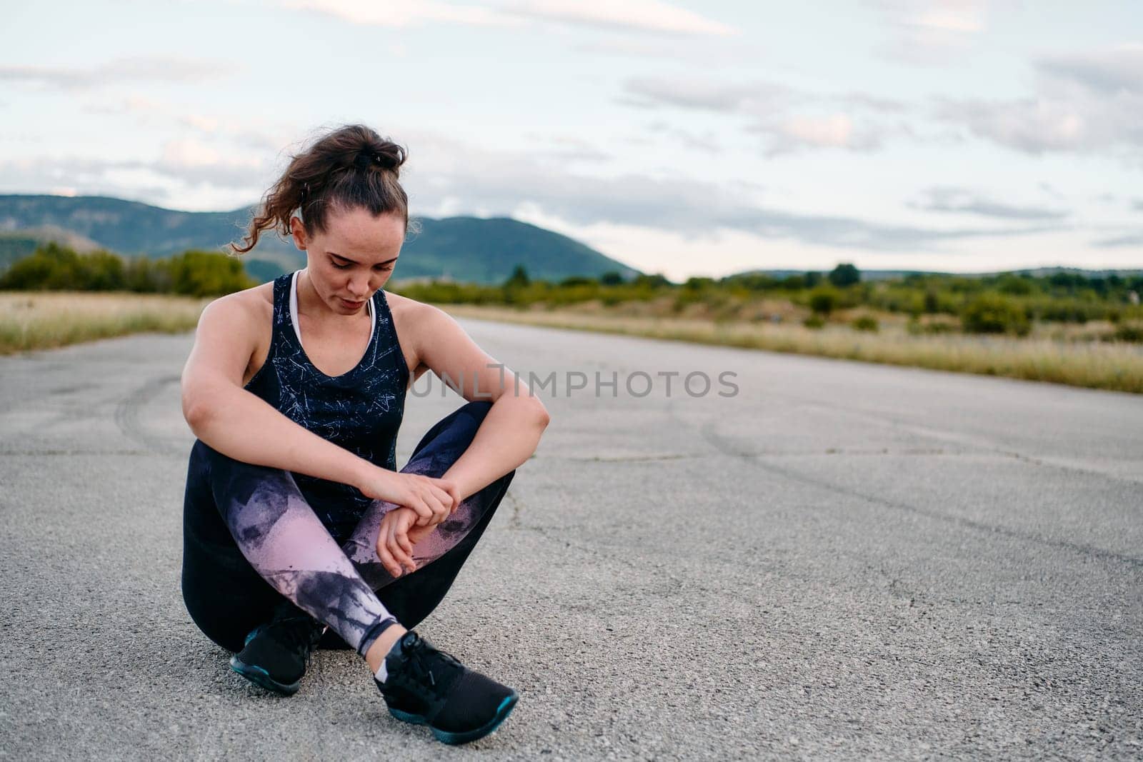 An athletic woman prepares herself for a morning run, embodying dedication and determination in her fitness routine