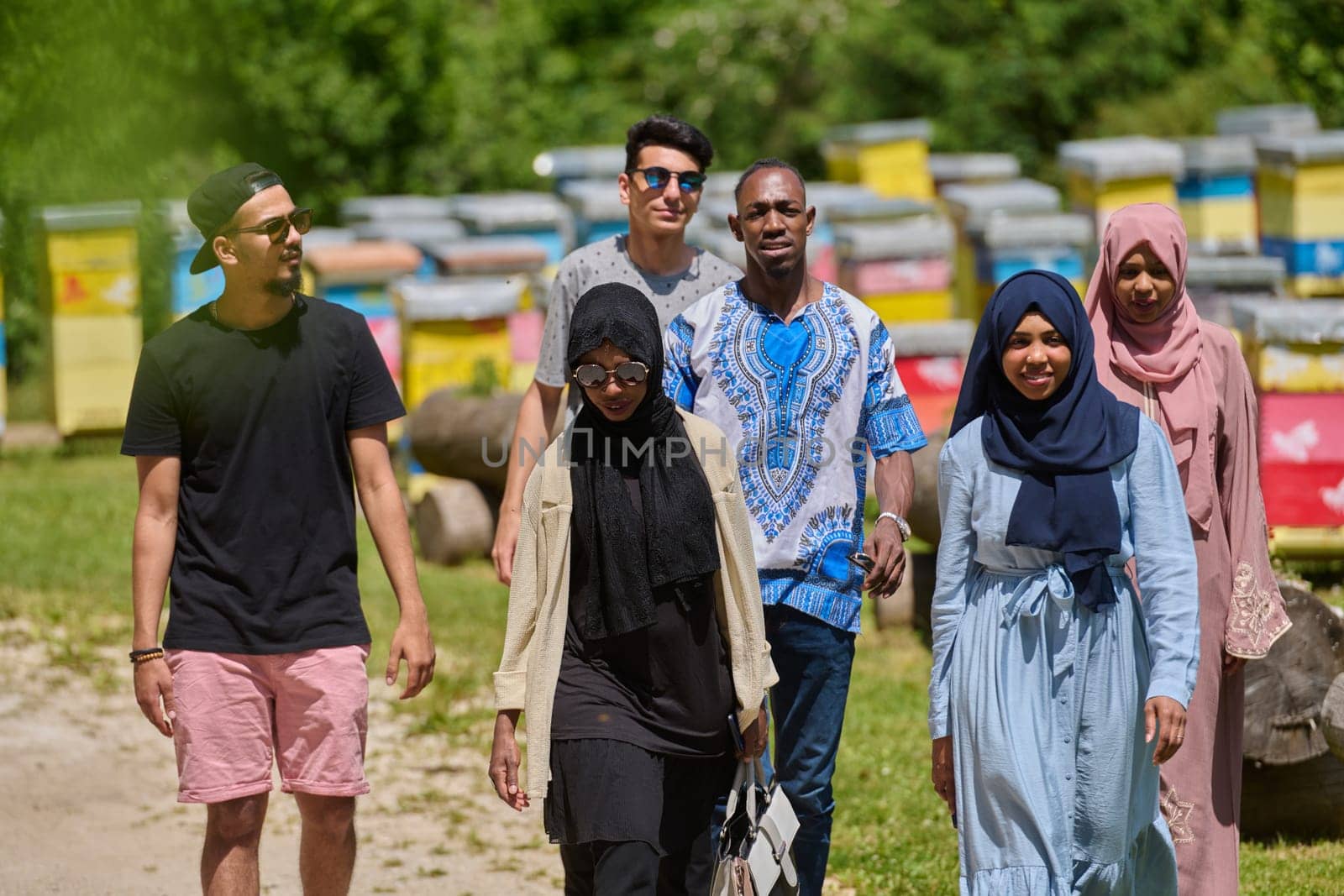 A diverse group of young friends and entrepreneurs explore small honey production businesses in the natural setting of the countryside