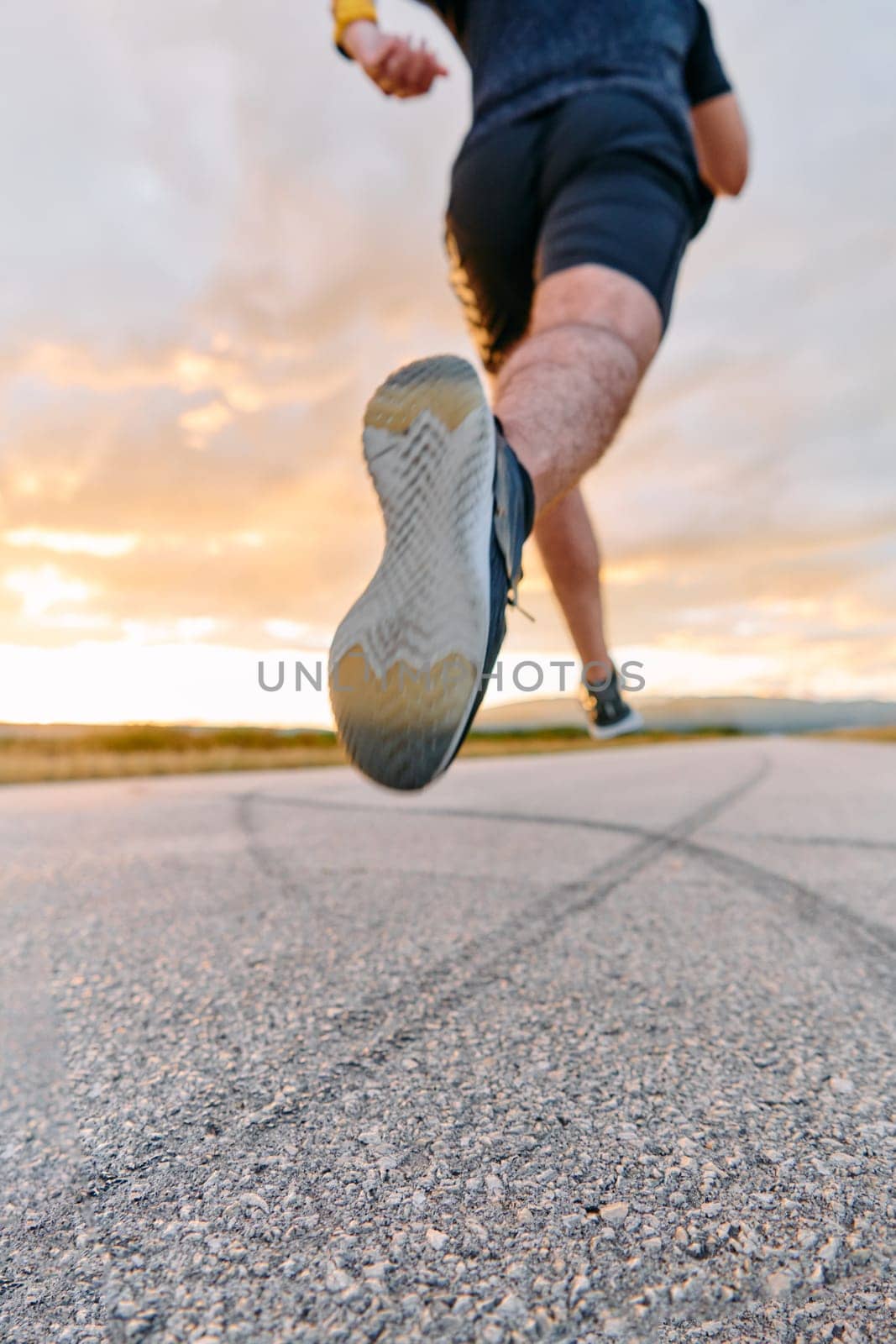 A breathtaking wide shot captures a determined man gracefully running against the backdrop of a vibrant sunset