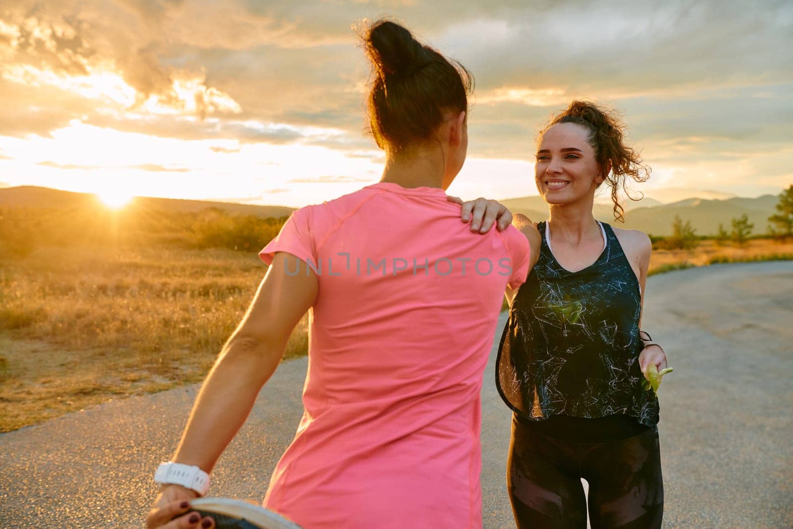 Two women athletes are seen stretching after an intense run, epitomizing dedication to fitness and appreciation for nature's beauty.