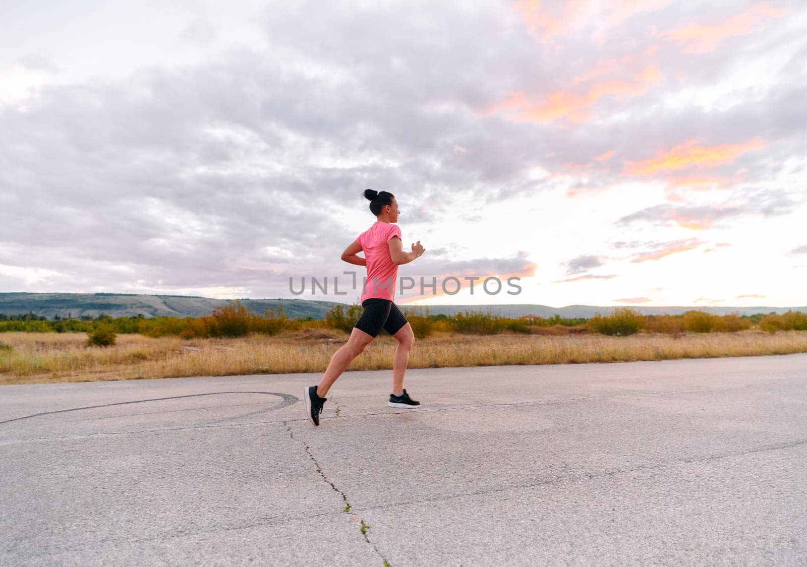 Determined Athlete Running in the Sun amidst Beautiful Nature by dotshock