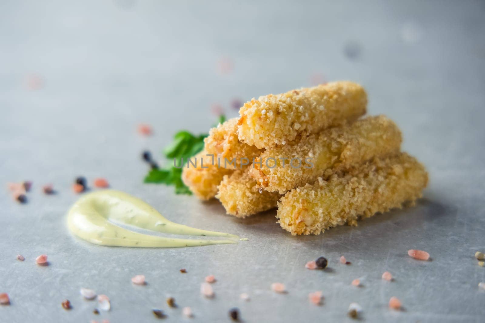 Breaded mozzarella cheese sticks with golden crispy crust on a wooden board. Beer appetizer by Mixa74