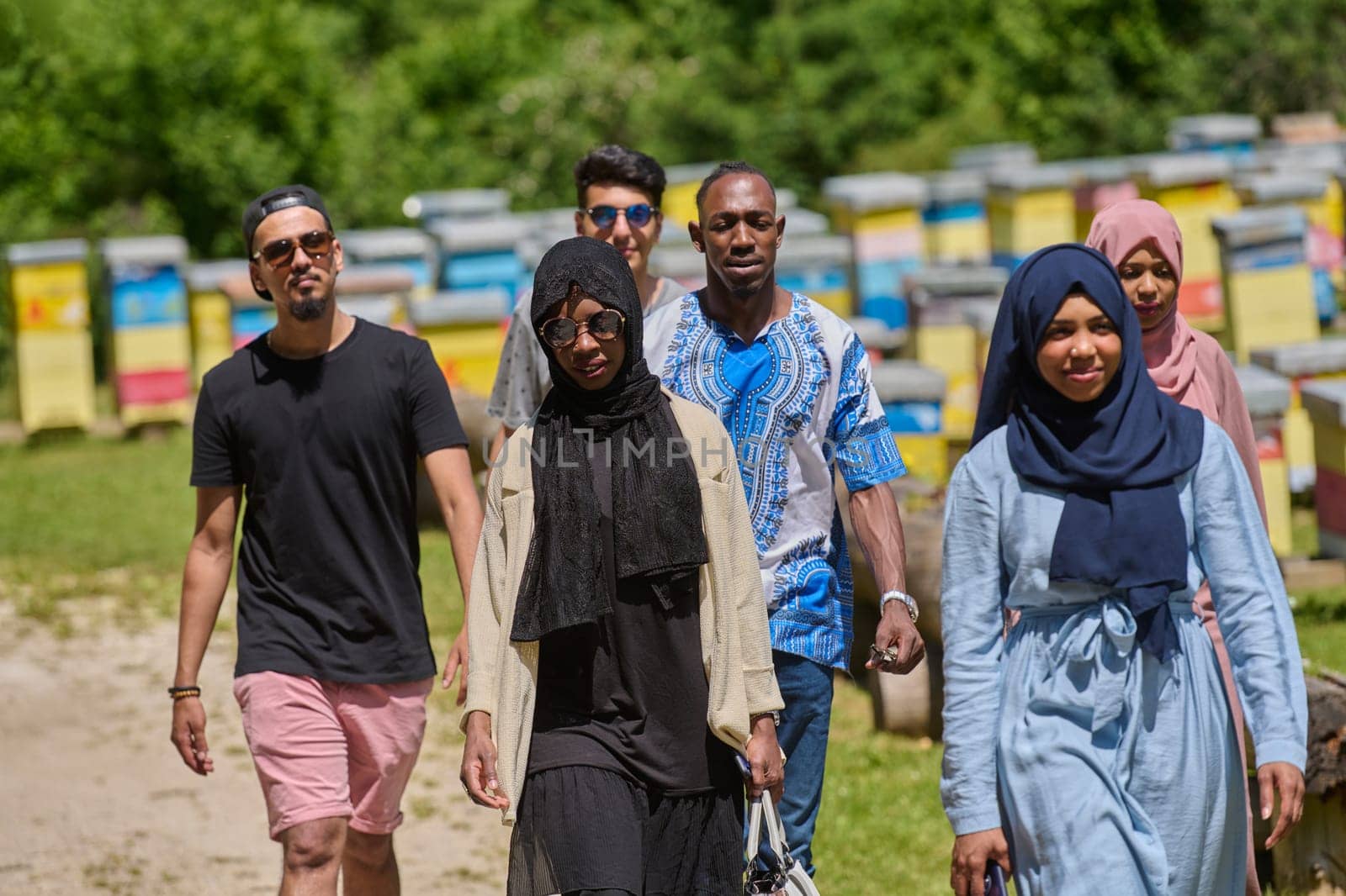 A diverse group of young friends and entrepreneurs explore small honey production businesses in the natural setting of the countryside. by dotshock