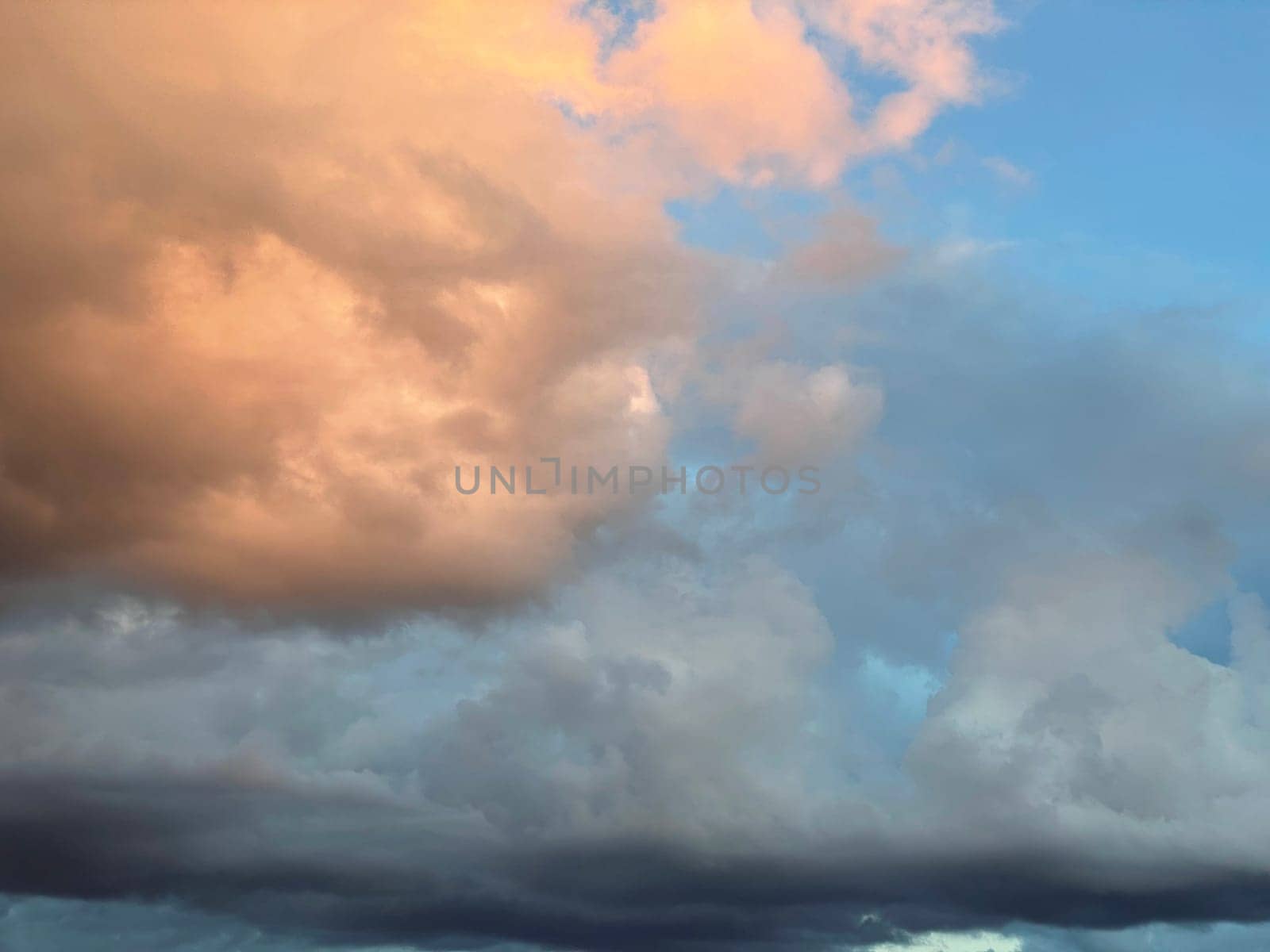 Sunset clouds in the sky. Natural texture and background. Dramatic sunset. Red-orange clouds against the blue sky. Sunset orange red yellow pink clouds against blue sky texture by Costin