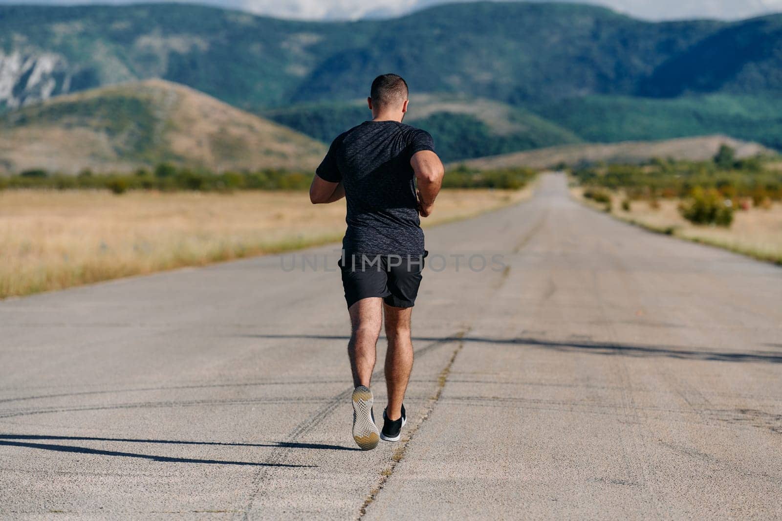 An athletic man jogs under the sun, conditioning his body for life's extreme challenges, exuding determination and strength in his preparation for the journey ahead