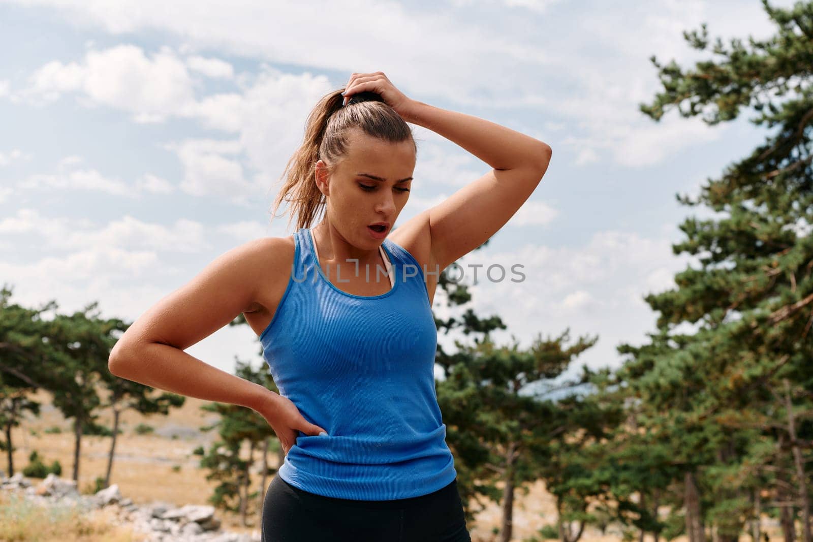 A woman takes a moment to rest and recuperate after an intense run, finding solace and rejuvenation in the tranquility of her surroundings.