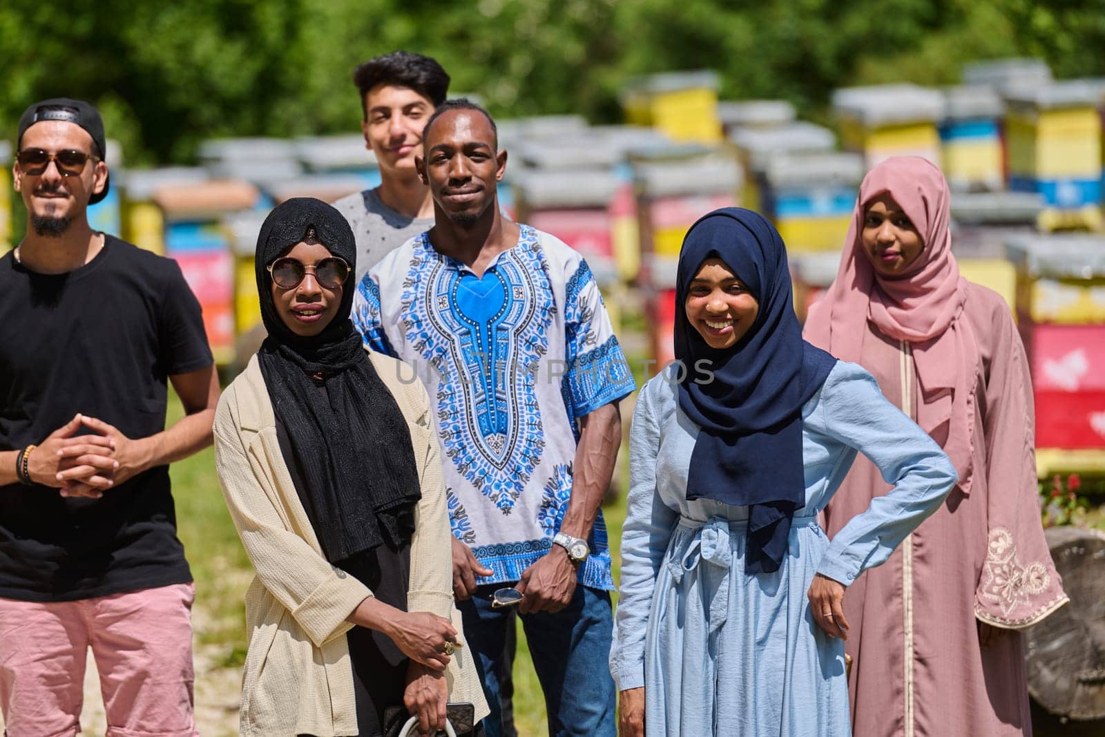 A diverse group of young friends and entrepreneurs explore small honey production businesses in the natural setting of the countryside. by dotshock