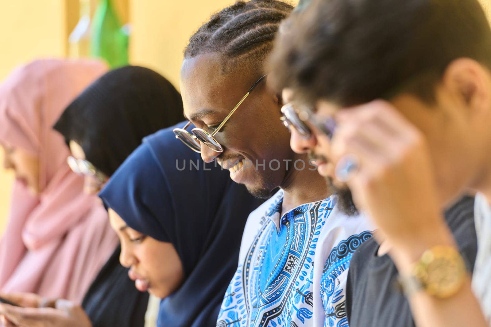 Diverse Teen Group Standing Together Against Wall Using Smartphones by dotshock