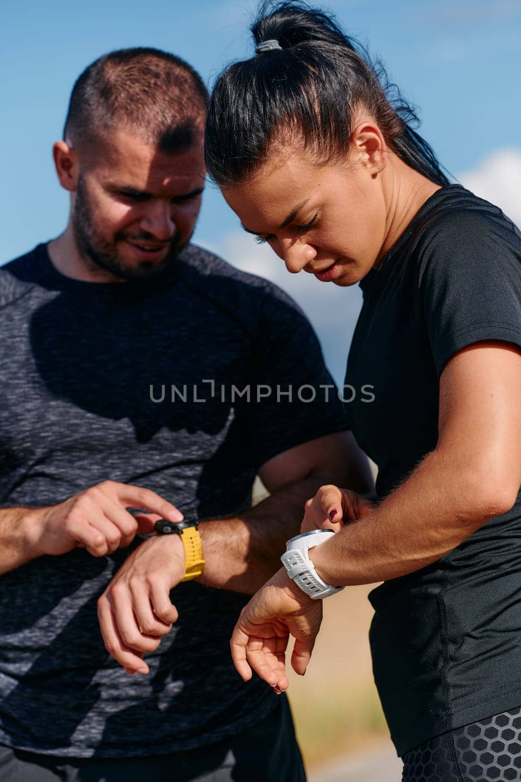 A couple checks their running results together on a smartwatch, sharing the joy of progress and fitness achievement after their run.