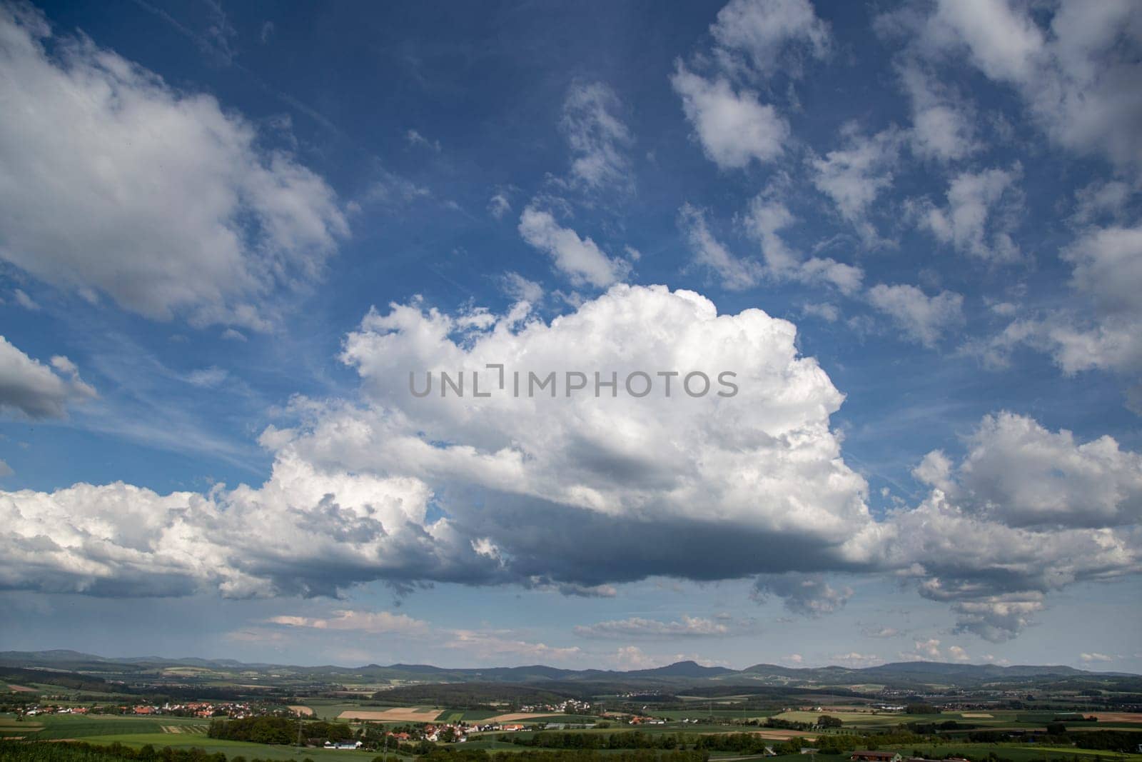 Beauty cloud against a blue sky background. Sky slouds. Blue sky with cloudy weather, nature cloud over the landskape. Over the land white clouds, blue sky and sun. by Costin