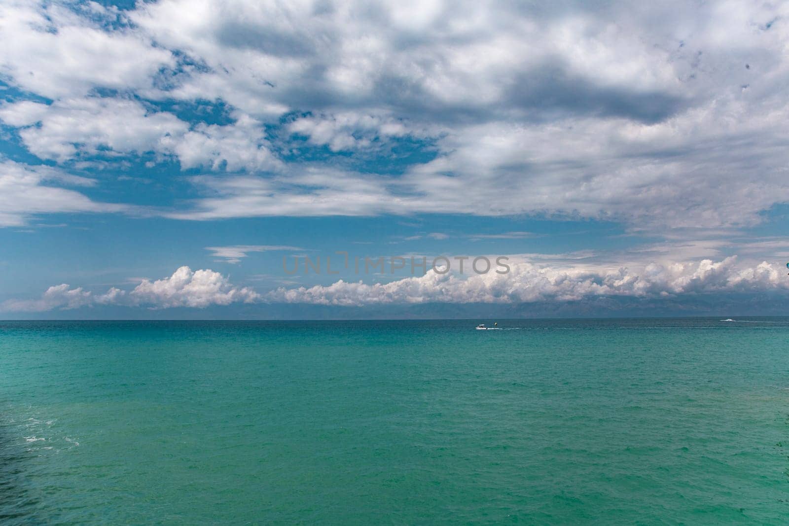 Beauty cloud against a blue sky background. Sky slouds. Blue sky with cloudy weather, nature cloud over the sea. Over the sea white clouds, blue sky and sun. by Costin