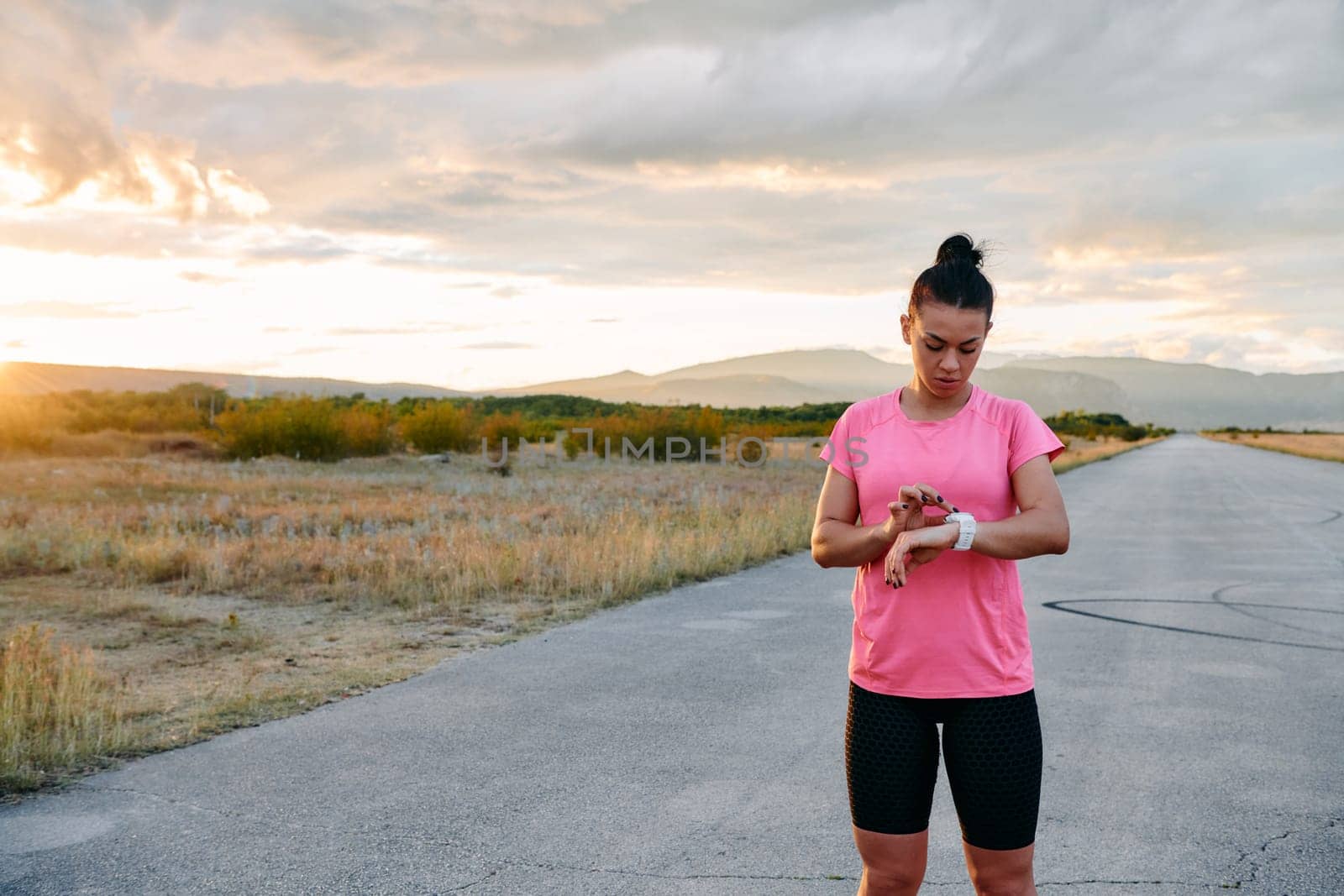 A woman closely examining fitness analytics on her smartwatch display, reflecting on her post run performance with technological precision