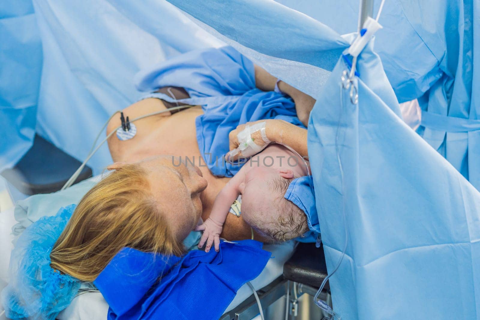 Baby on mother's chest immediately after birth in a hospital. The mother and newborn share a tender moment, emphasizing the bond and emotional connection. The medical staff ensures a safe and caring environment.