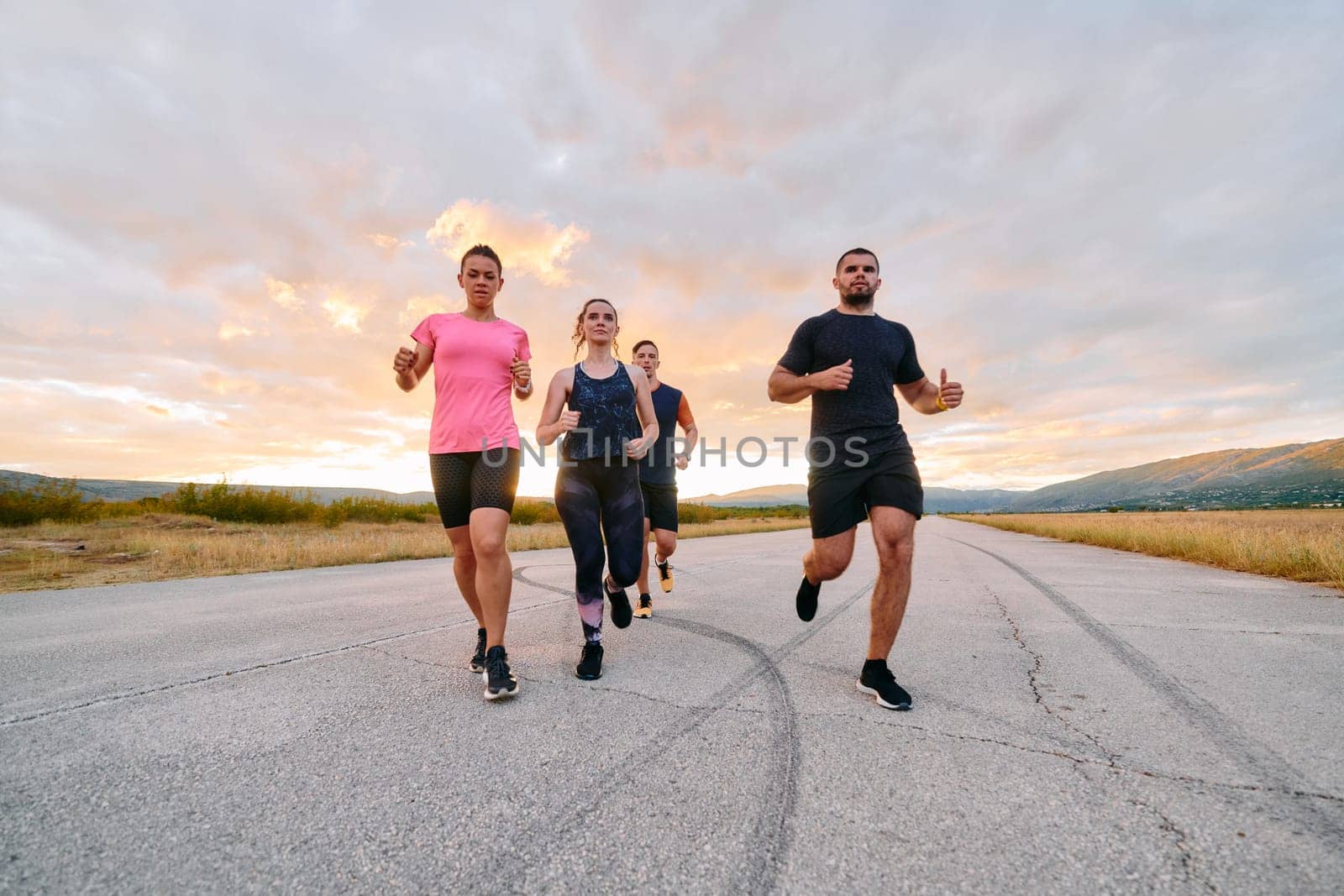 A professional athletic team as they train rigorously, running towards peak performance in preparation for an upcoming marathon.