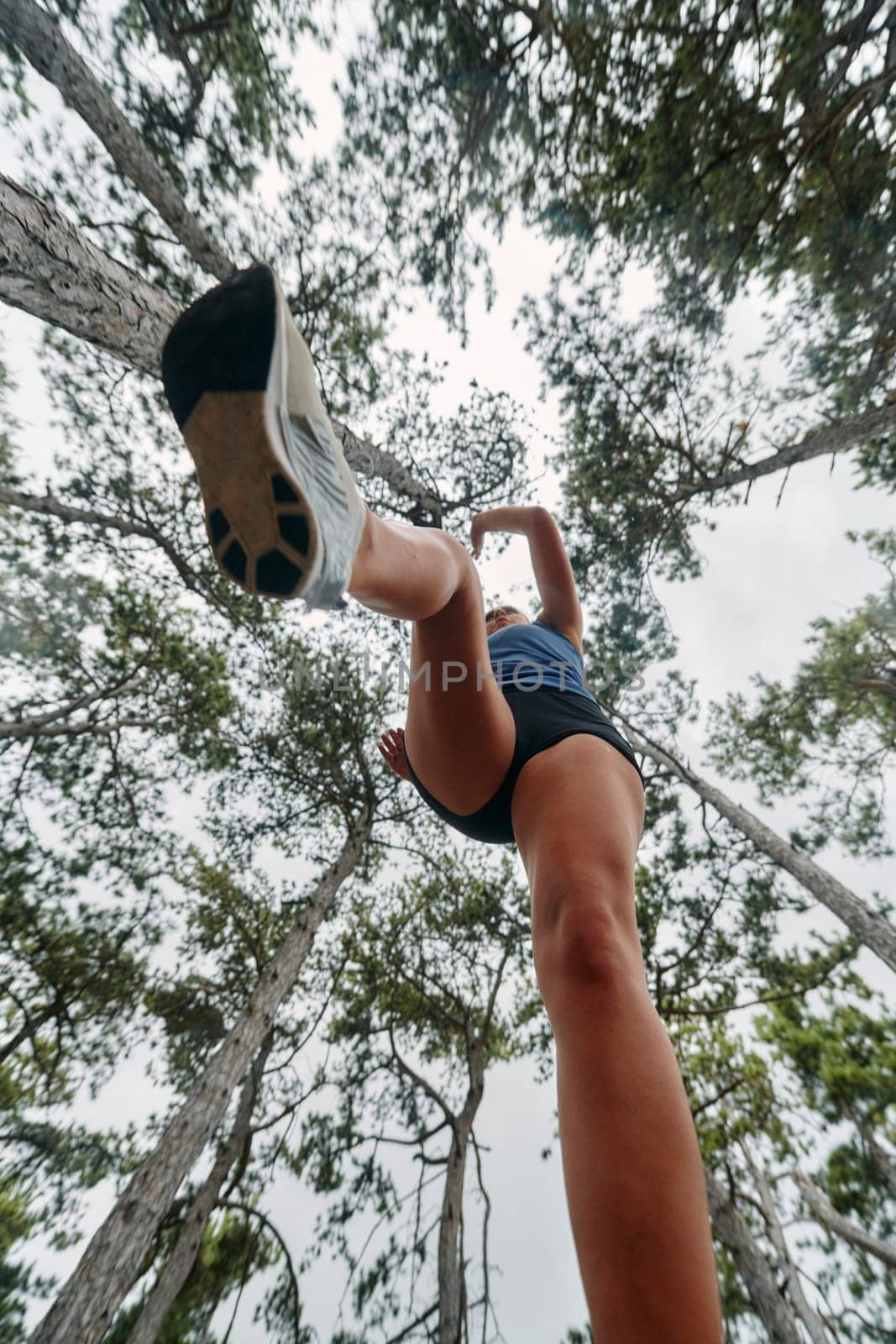 A brave woman traverses through the forest, fearlessly leaping over dangerous obstacles with determination and agility, showcasing her adventurous spirit and athletic prowess.