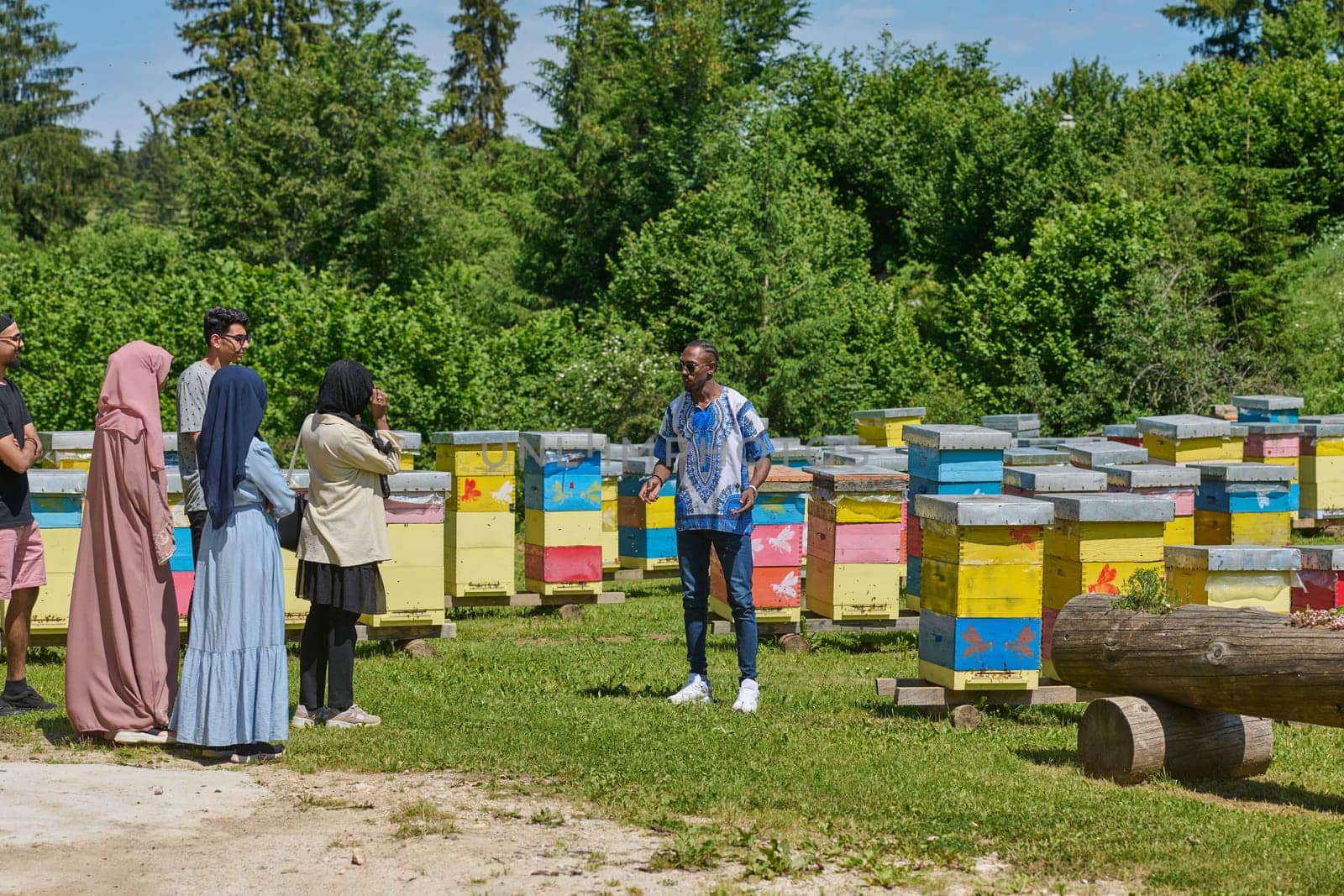 A diverse group of young friends and entrepreneurs explore small honey production businesses in the natural setting of the countryside. by dotshock