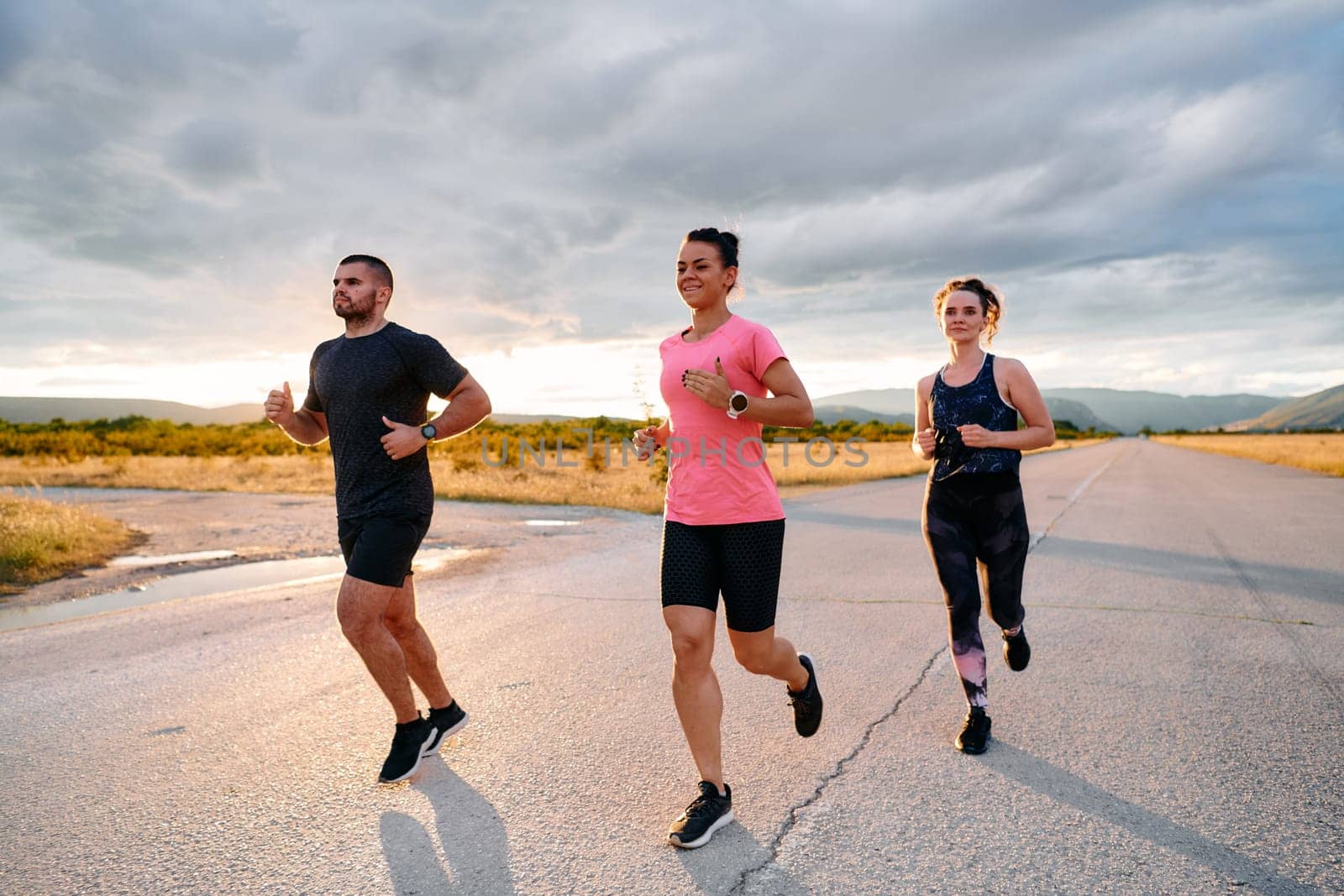 Athlete Leading Group Run at Sunset Amidst Stunning Nature by dotshock