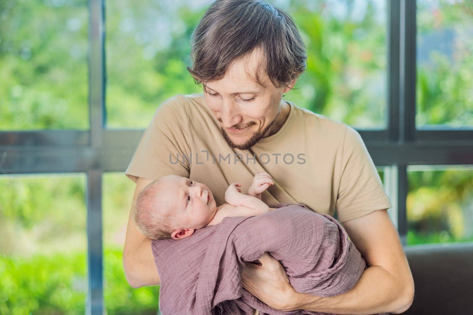 Dad and newborn at home. This tender moment captures the bond between father and child in a loving and comfortable family environment highlighting the joys of parenthood and the warmth of home.