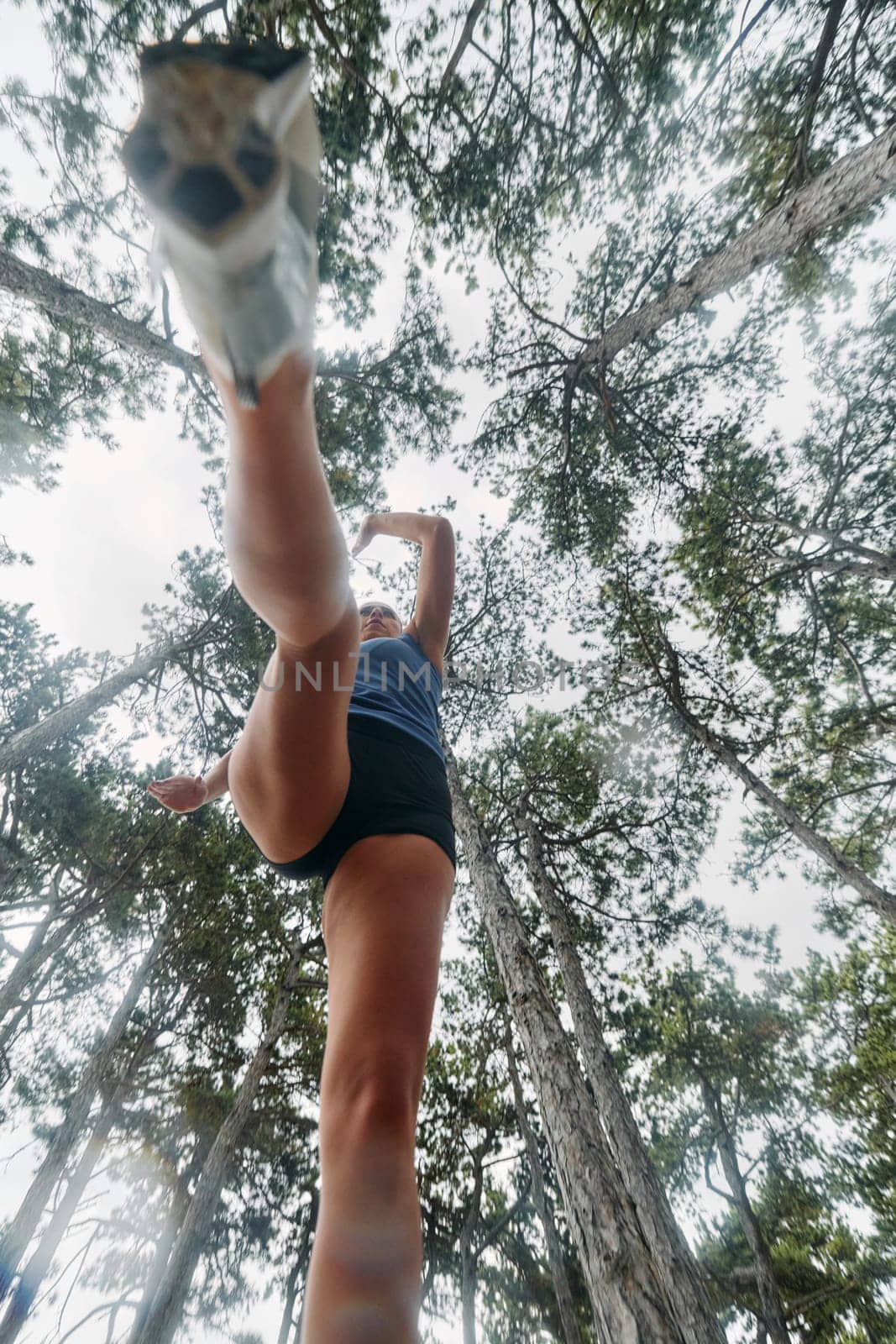 A brave woman traverses through the forest, fearlessly leaping over dangerous obstacles with determination and agility, showcasing her adventurous spirit and athletic prowess.